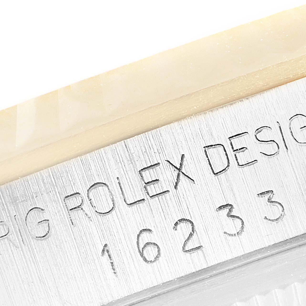 The image shows a close-up of the case side of the Rolex Datejust 16233 Men's Steel and Gold (two tone) Champagne Dial 16233 Men's Steel and Gold (two tone) Champagne Dial, with "ROLEX DESIGN" and model number engraved.