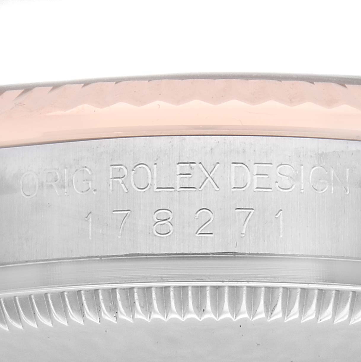 The image shows a close-up of the side of a Rolex Mid-Size 178271 Women
s Steel and Gold (two tone) Pink Dial 178271 Women
s Steel and Gold (two tone) Pink Dial model, highlighting the engraved serial number and bezel edge.