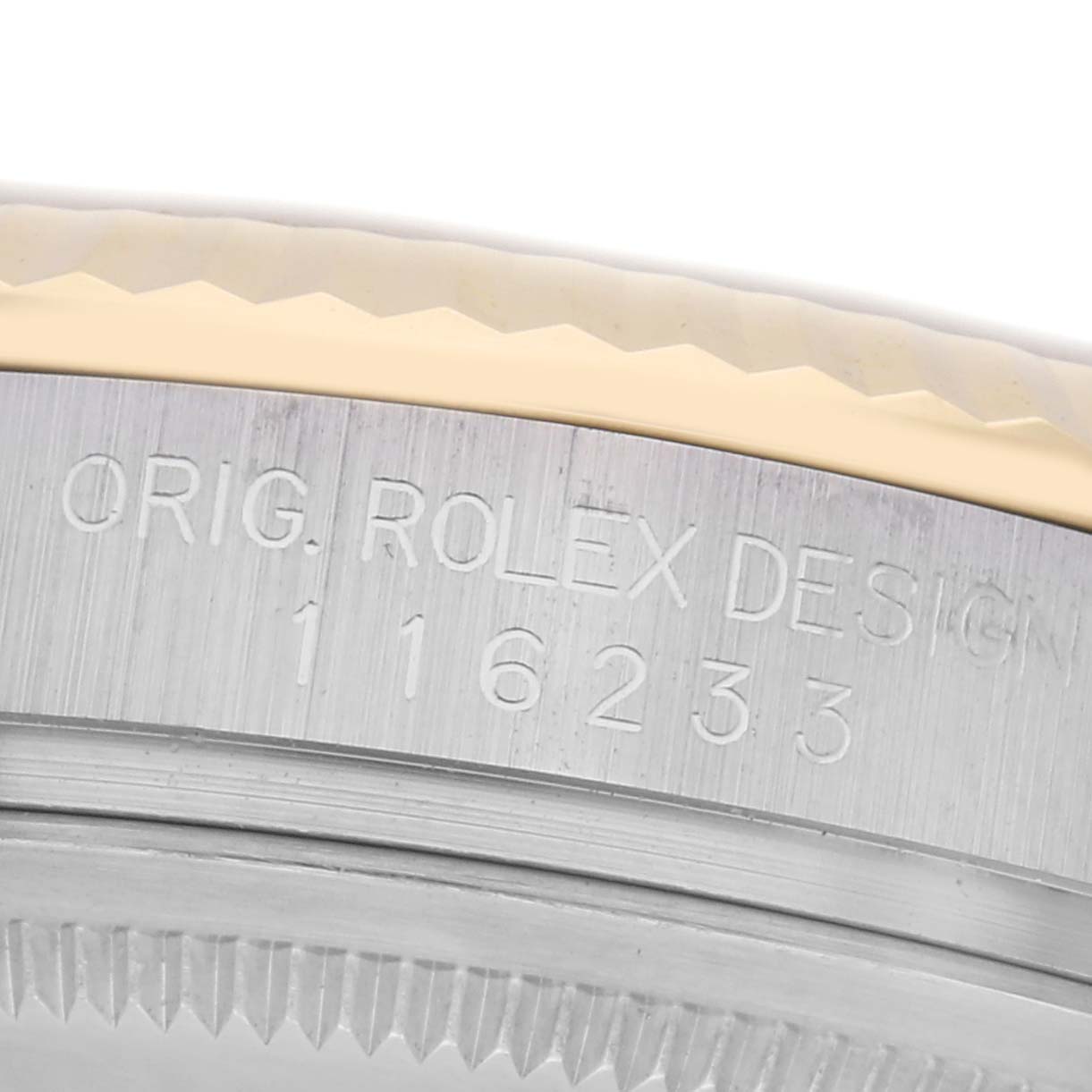 The image shows a close-up of the side of a Rolex Datejust 116233 Men
s Steel and Gold (two tone) Champagne Dial 116233 Men
s Steel and Gold (two tone) Champagne Dial case, featuring model details engraved on the bezel
s edge.