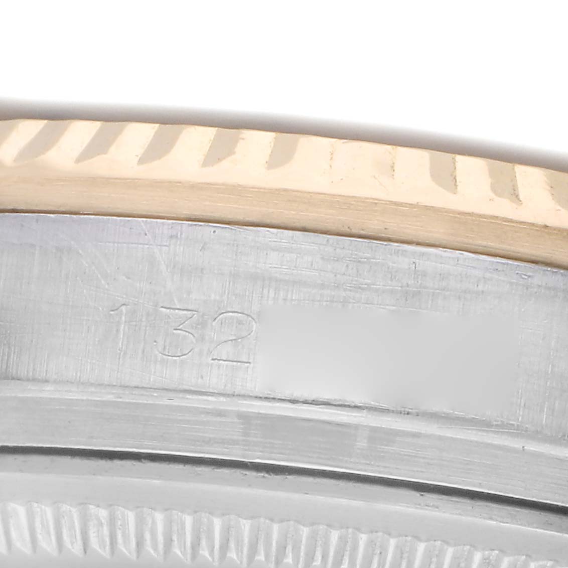 The image shows a close-up of the fluted bezel and case edge of a Rolex Datejust 1603 Men
s Steel and Gold (two tone) Champagne Dial 1603 Men
s Steel and Gold (two tone) Champagne Dial watch, displaying detailed engraving.