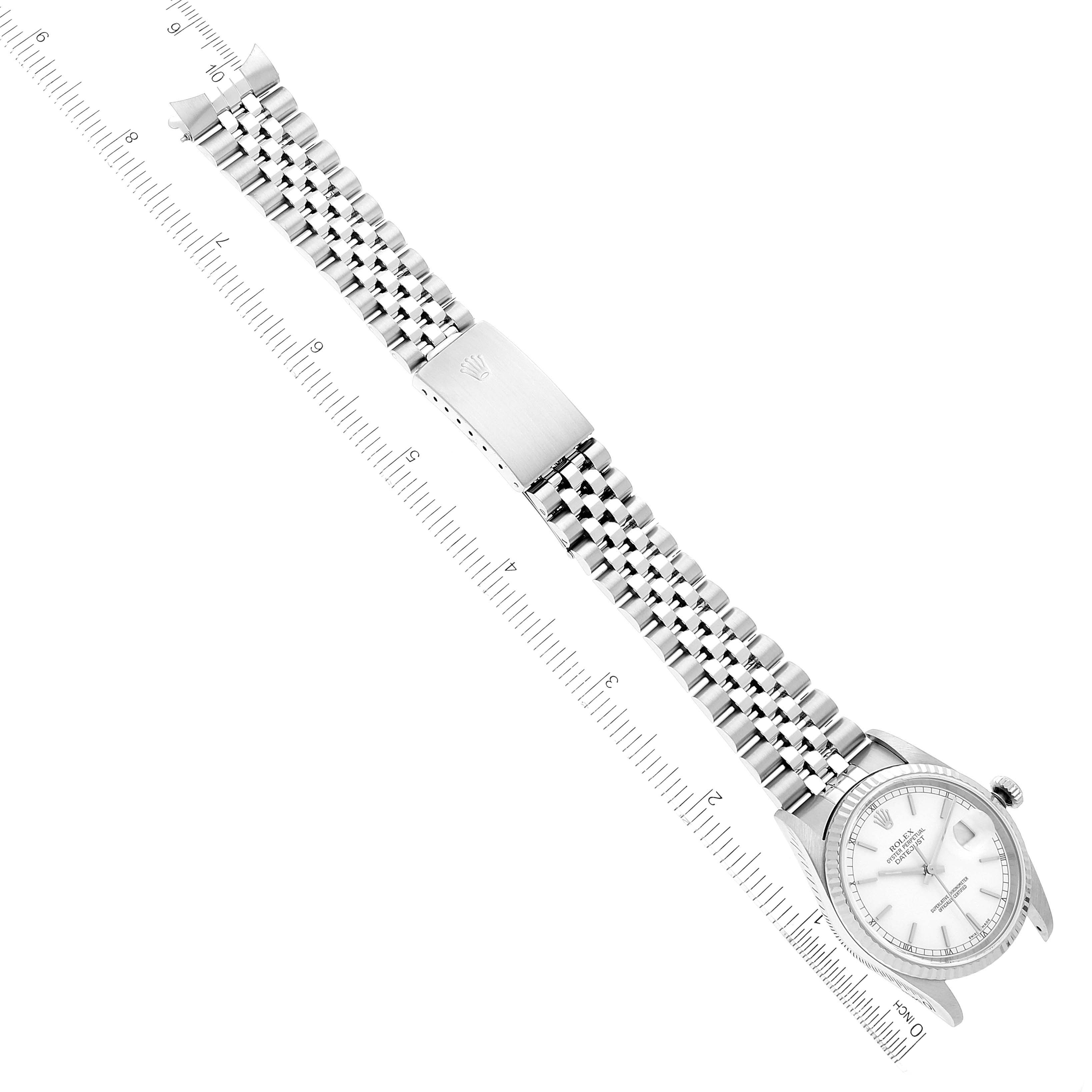 The image shows a Rolex Datejust 16234 Men's Stainless Steel White Dial 16234 Men's Stainless Steel White Dial watch laid flat, highlighting its face, stainless steel bracelet, and clasp, with a ruler alongside for measurement.