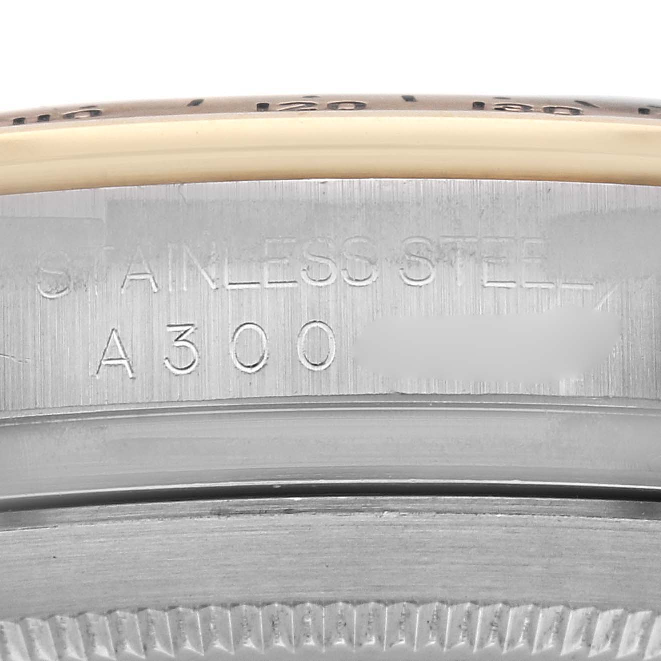 The image shows a close-up of the case side of a Rolex Daytona 16523 Men
s Steel and Gold (two tone) White Dial 16523 Men
s Steel and Gold (two tone) White Dial watch, highlighting the stainless steel material and model engraving.