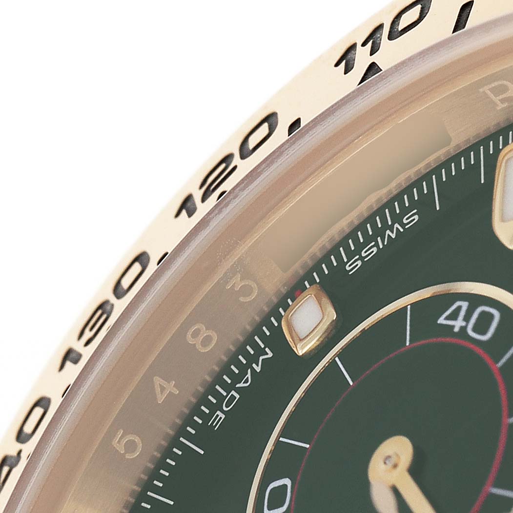 The image shows a close-up of the bezel and part of the dial on a Rolex Daytona 116508 Mens Yellow Gold Green Dial, highlighting the tachymetric scale and hour markers.