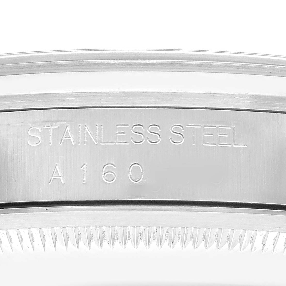The image shows a close-up of the engraved side of the case of a Rolex Explorer 14270 Men's Stainless Steel Black Dial, highlighting the "Stainless Steel" inscription.