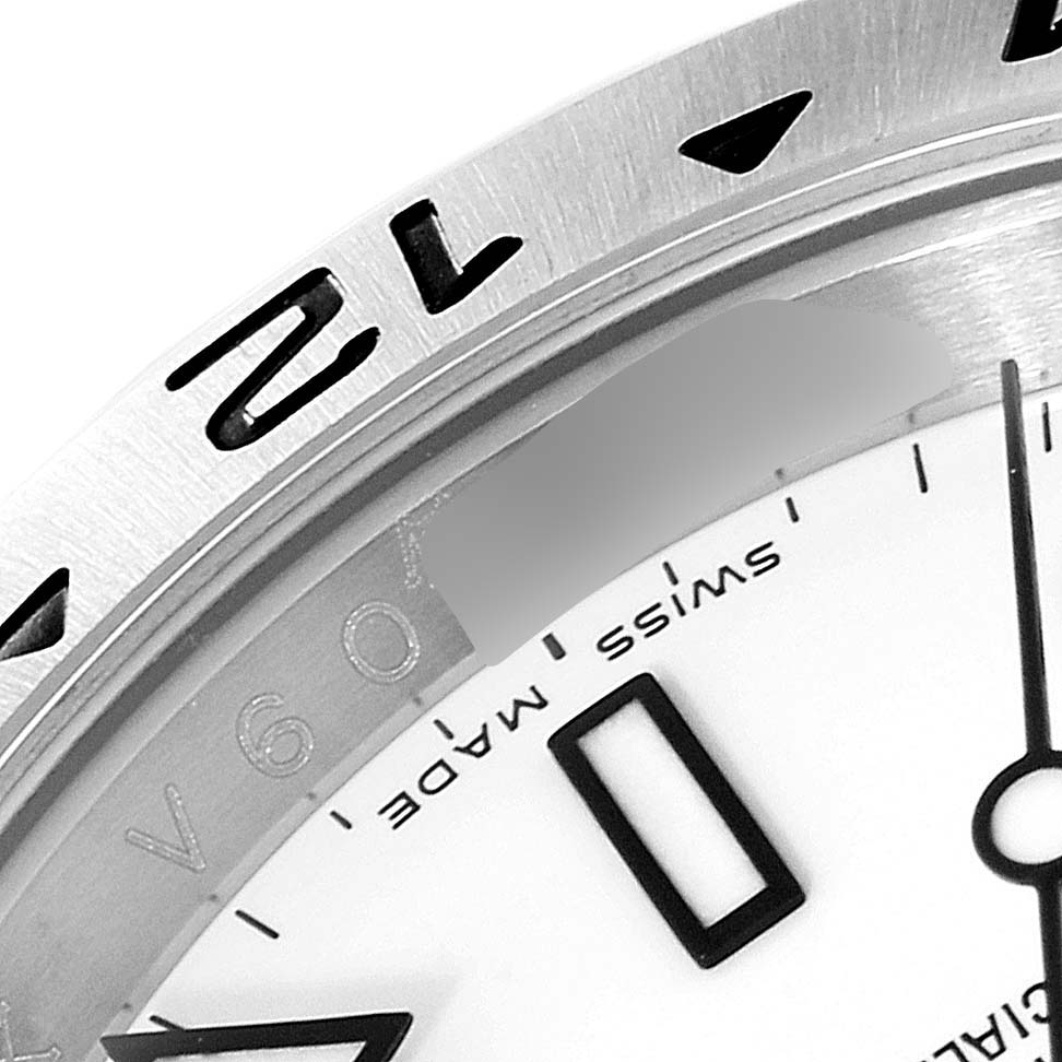 The image shows a close-up of the Rolex Explorer 16570 Men's Stainless Steel White Dial 16570 Men's Stainless Steel White Dial watch's bezel, part of the dial, and the "Swiss Made" marking.