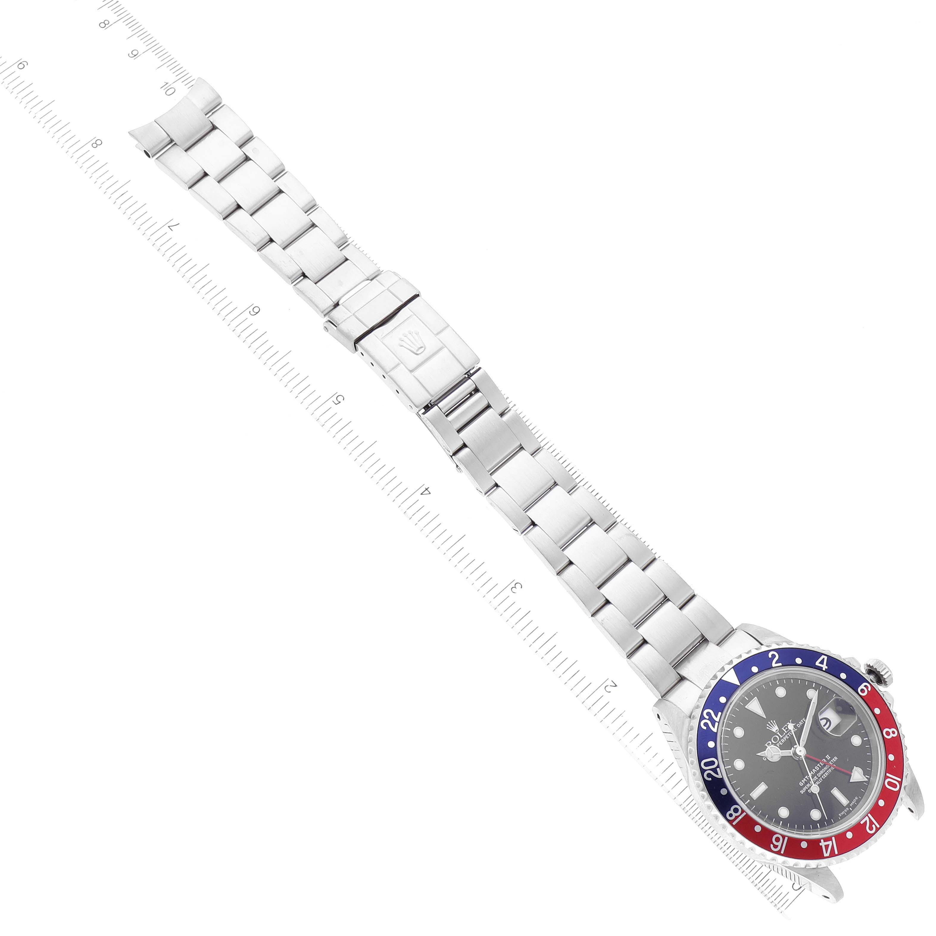 The image shows a top view of a Rolex GMT-Master 16710 Men
s Stainless Steel Black Dial 16710 Men
s Stainless Steel Black Dial watch and bracelet, aligned with a ruler for measurement.