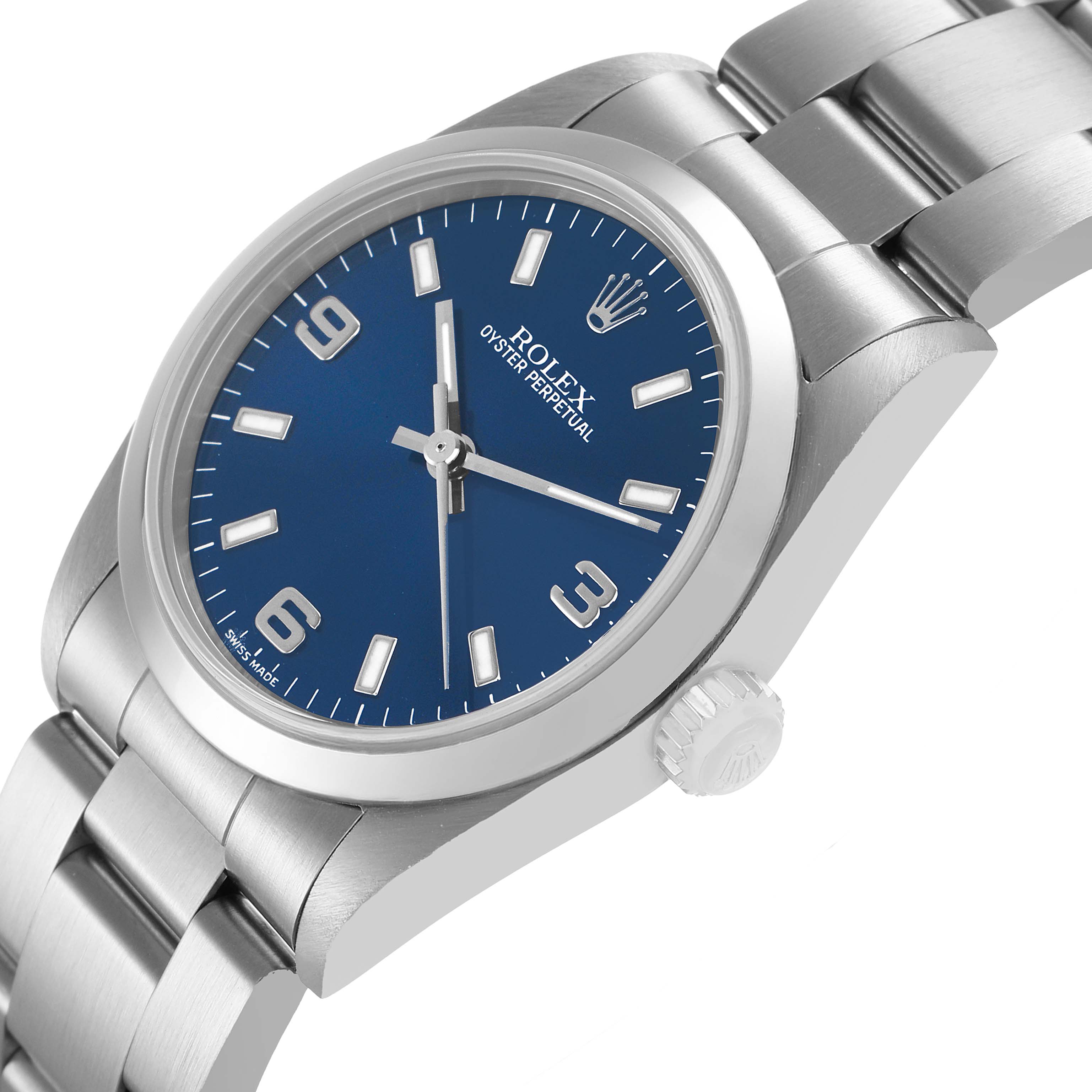 The Rolex Mid-Size 77080 Women's Stainless Steel Blue Dial watch is shown at an angled side view, highlighting the crown, bracelet, and blue dial.