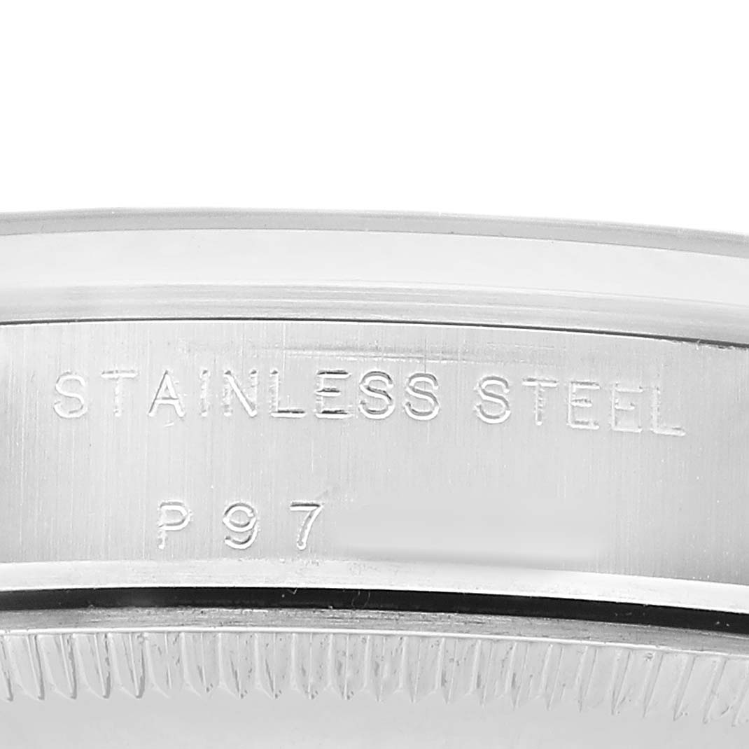 The image shows a close-up of the case back edge of a Rolex Oyster Perpetual 77080 Women's Stainless Steel Black Dial watch, highlighting "Stainless Steel" engraving.