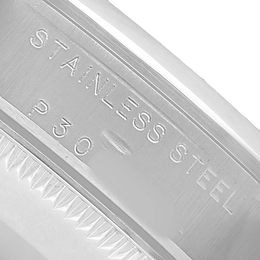 The image shows a close-up of the inner stainless steel case of a Rolex Oyster Perpetual 77080 Women's Stainless Steel Black Dial watch, highlighting engravings.