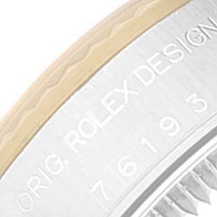 The image shows a close-up of the side of a Rolex Oyster Perpetual 76193 Women's Steel and Gold (two tone) Silver Dial 76193 Women's Steel and Gold (two tone) Silver Dial watch case, displaying the "ORIG. ROLEX DESIGN" engraving and part of the serial number.
