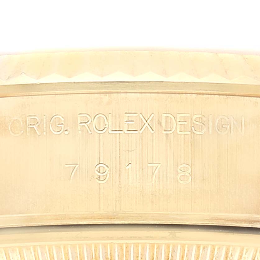 This image shows a close-up of the engraved side of a Rolex President 79178 Women
s Yellow Gold Champagne Dial 79178 Women
s Yellow Gold Champagne Dial model with the serial number and "Rolex Design."