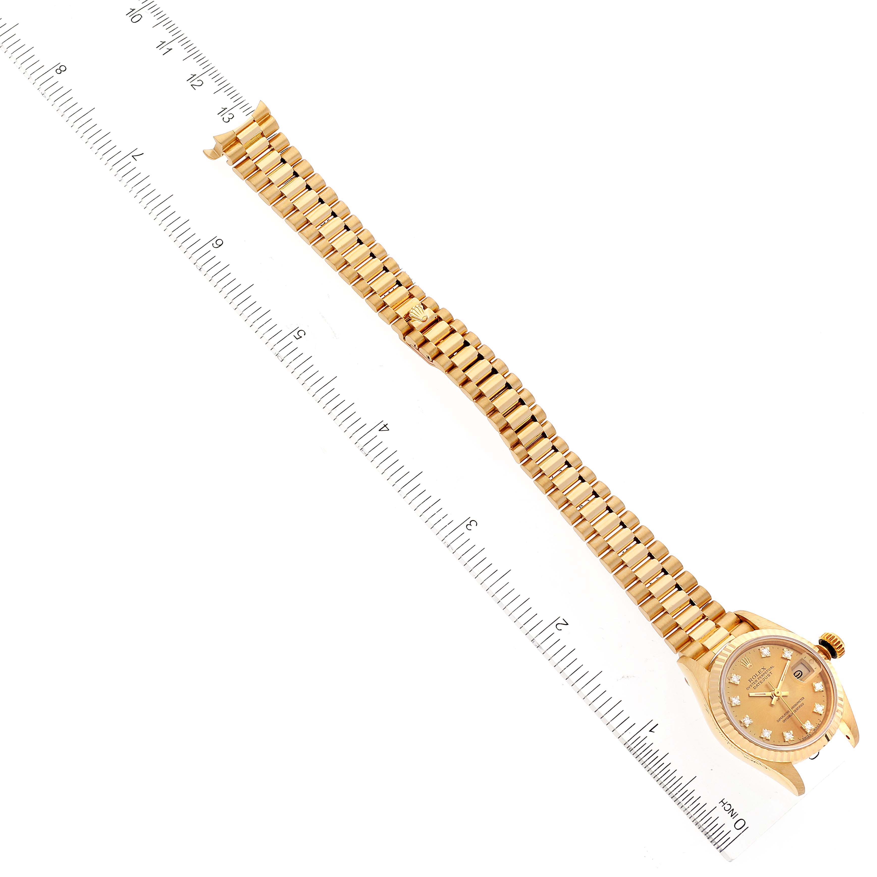This image shows a Rolex President 69178 Women
s Yellow Gold Champagne Dial 69178 Women
s Yellow Gold Champagne Dial watch, highlighting its band and face, at a diagonal angle with a ruler for scale.
