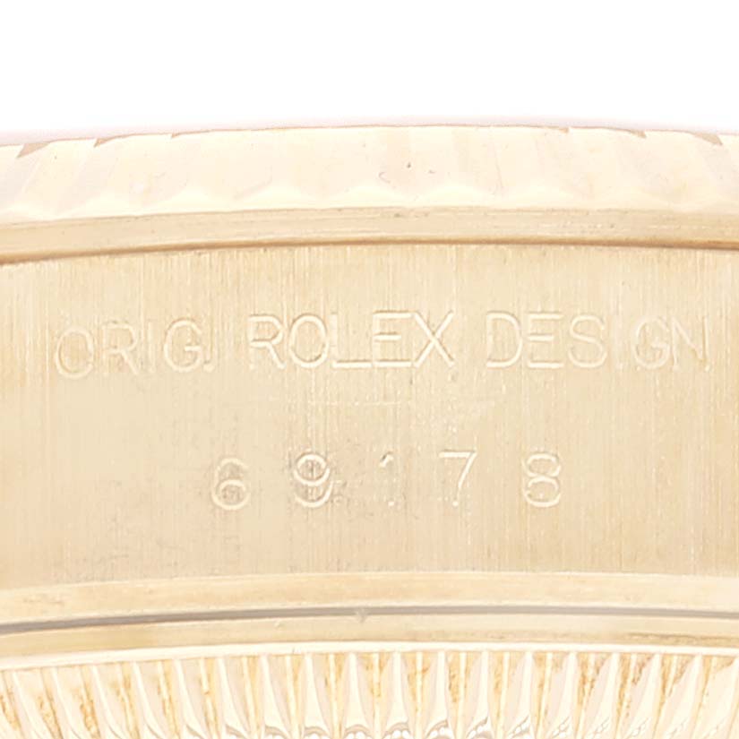 The image shows a close-up of the outer rim or bezel of a Rolex President 69178 Women
s Yellow Gold Champagne Dial 69178 Women
s Yellow Gold Champagne Dial model watch, displaying engraved text and numbers.