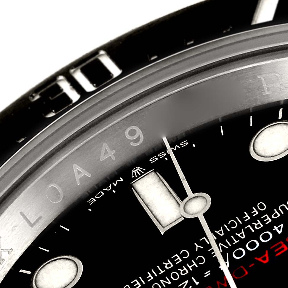 The image shows a close-up of the dial and bezel of the Sea-Dweller model by Rolex, highlighting the text and markers.