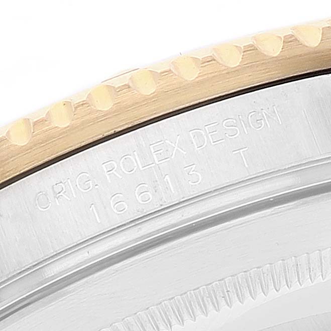 The image shows a close-up angle of the engraved side of the center case of a Rolex Submariner 16613 Men
s Steel and Gold (two tone) Blue Dial 16613 Men
s Steel and Gold (two tone) Blue Dial watch model 16613.