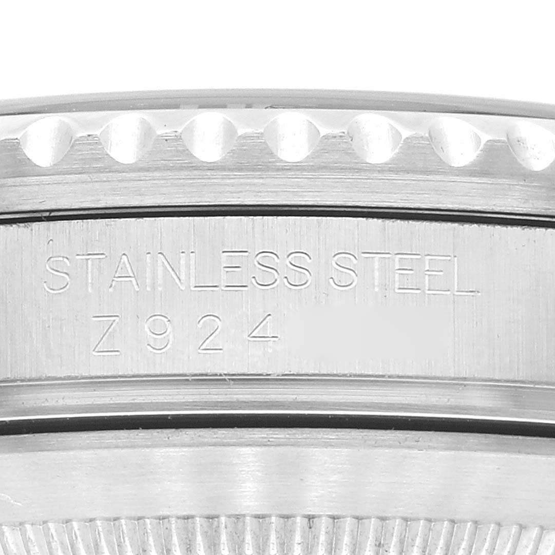 The image shows a close-up of the side engraving and bezel of a Rolex Submariner 16610 Men's Stainless Steel Black Dial 16610 Men's Stainless Steel Black Dial, highlighting the stainless steel material and serial number.