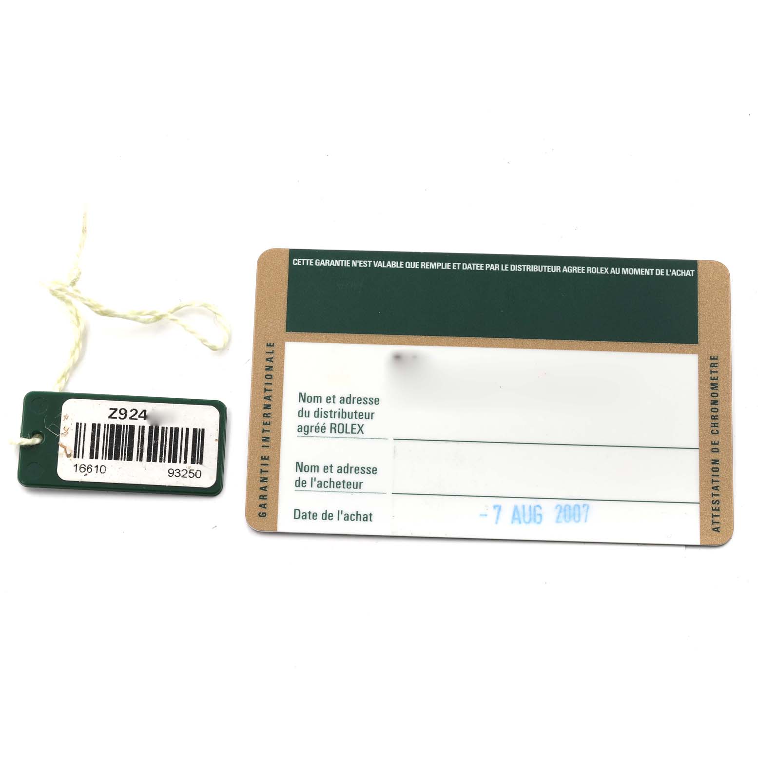 Shown are a Rolex Submariner 16610 Men's Stainless Steel Black Dial 16610 Men's Stainless Steel Black Dial warranty card from 2007 and a green tag with reference numbers.