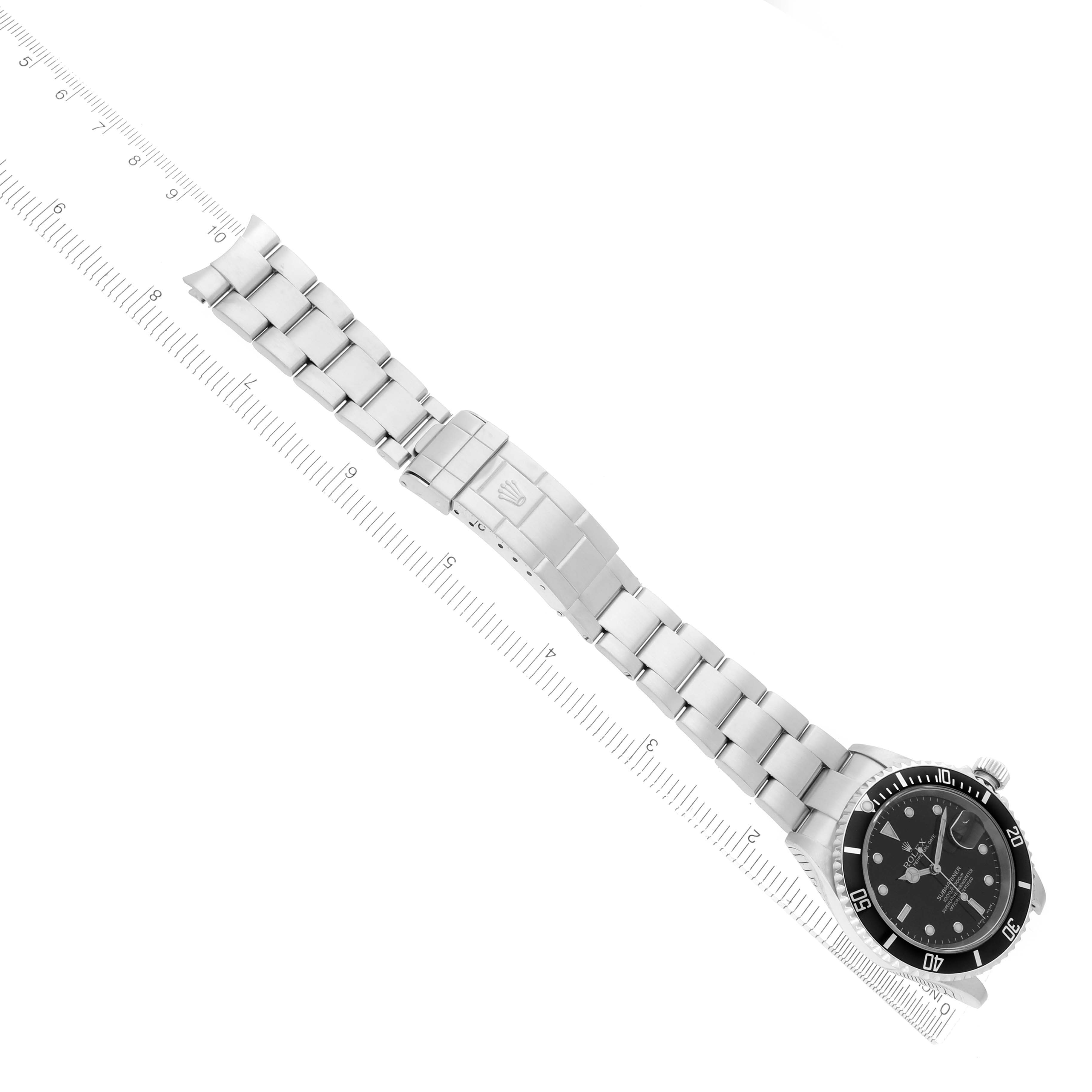 The image shows a Rolex Submariner 16610 Men
s Stainless Steel Black Dial 16610 Men
s Stainless Steel Black Dial watch from an overhead angle, displaying the full bracelet, clasp, and dial.