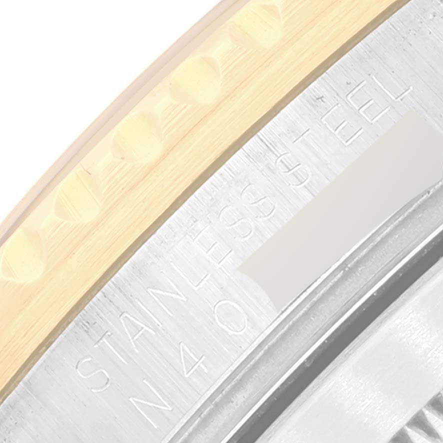 The image shows a close-up of the bezel and stainless steel case with engravings of a Rolex Submariner 16613 Men's Steel and Gold (two tone) Champagne Dial 16613 Men's Steel and Gold (two tone) Champagne Dial watch.