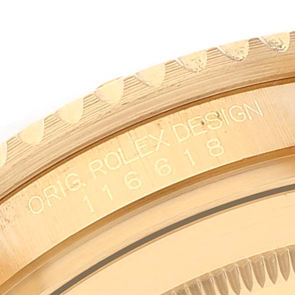 This close-up shows the engraved model number and "ORIG. ROLEX DESIGN" label on the case of a Rolex Submariner 116618 Men's Yellow Gold Blue Dial 116618 Men's Yellow Gold Blue Dial watch.