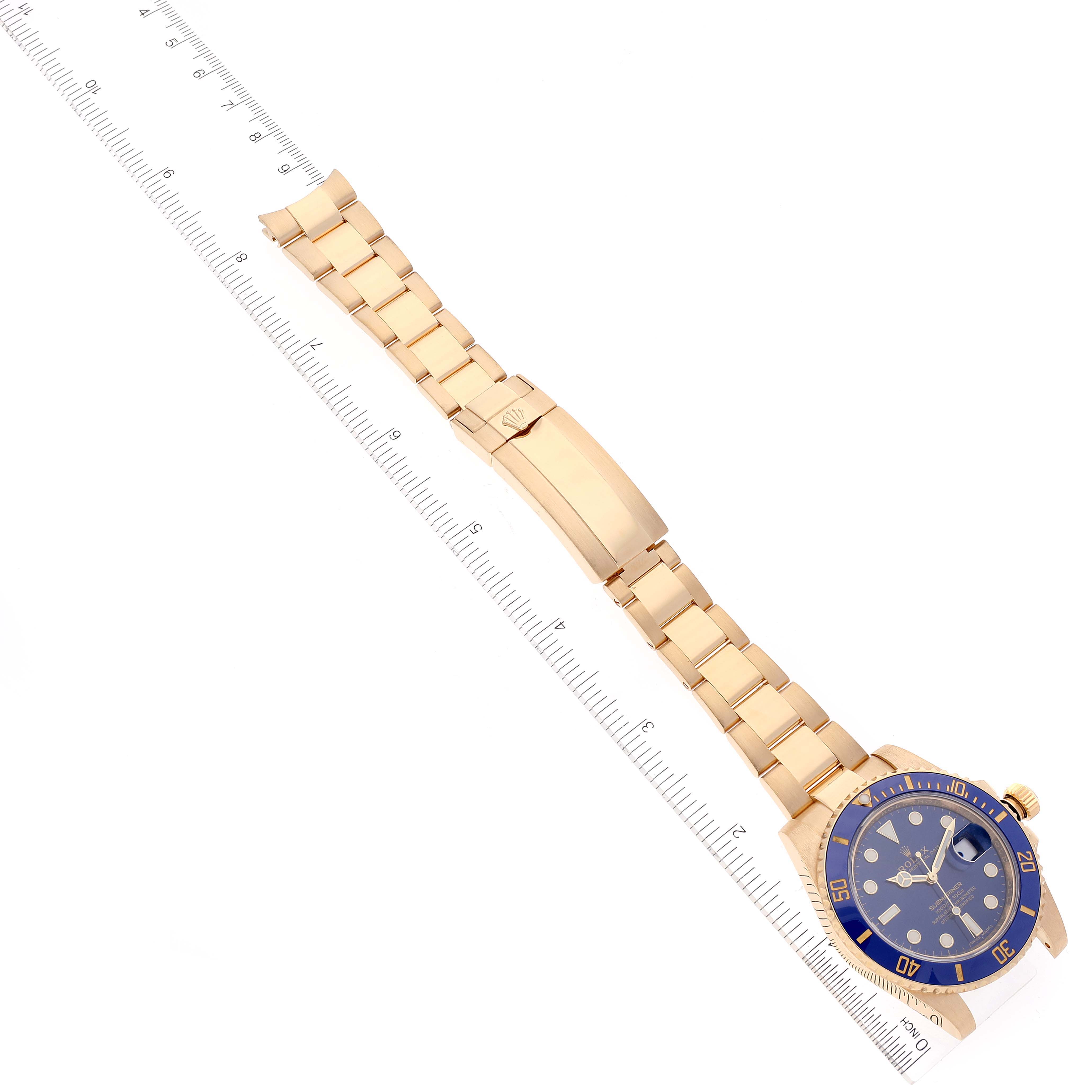 The image shows a Rolex Submariner 116618 Men's Yellow Gold Blue Dial 116618 Men's Yellow Gold Blue Dial watch lying flat, displaying the full bracelet, clasp, and blue dial, alongside a measuring ruler.