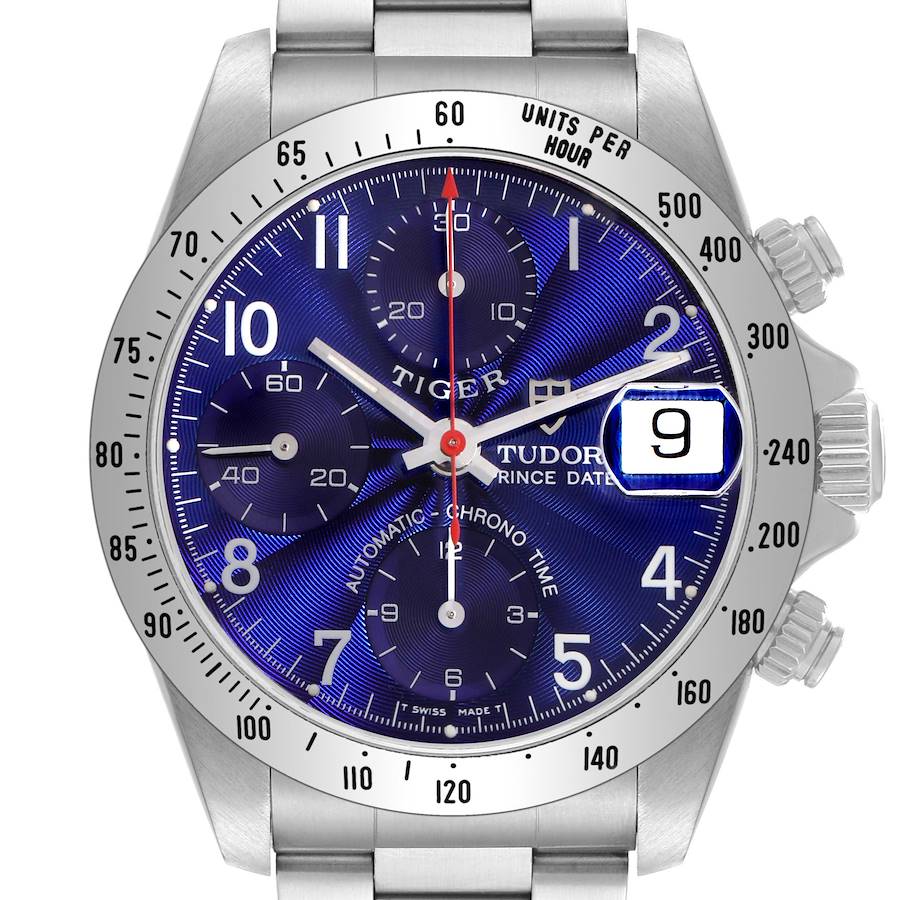 The Tudor Tiger watch is shown straight-on, highlighting its blue dial, chronograph subdials, and date window.