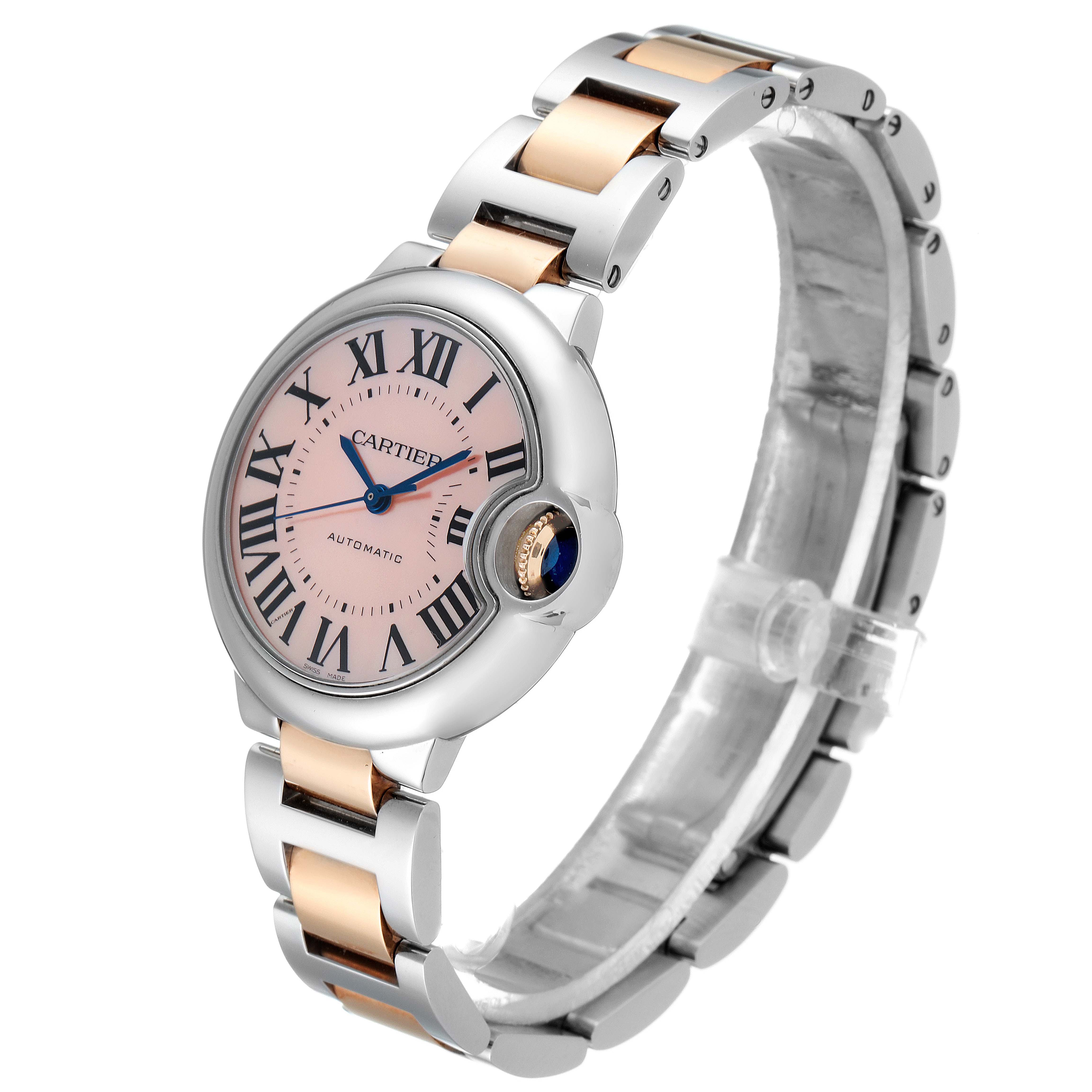 The image shows a Ballon Bleu de Cartier watch at a three-quarter angle, highlighting its pink dial and steel and gold bracelet.
