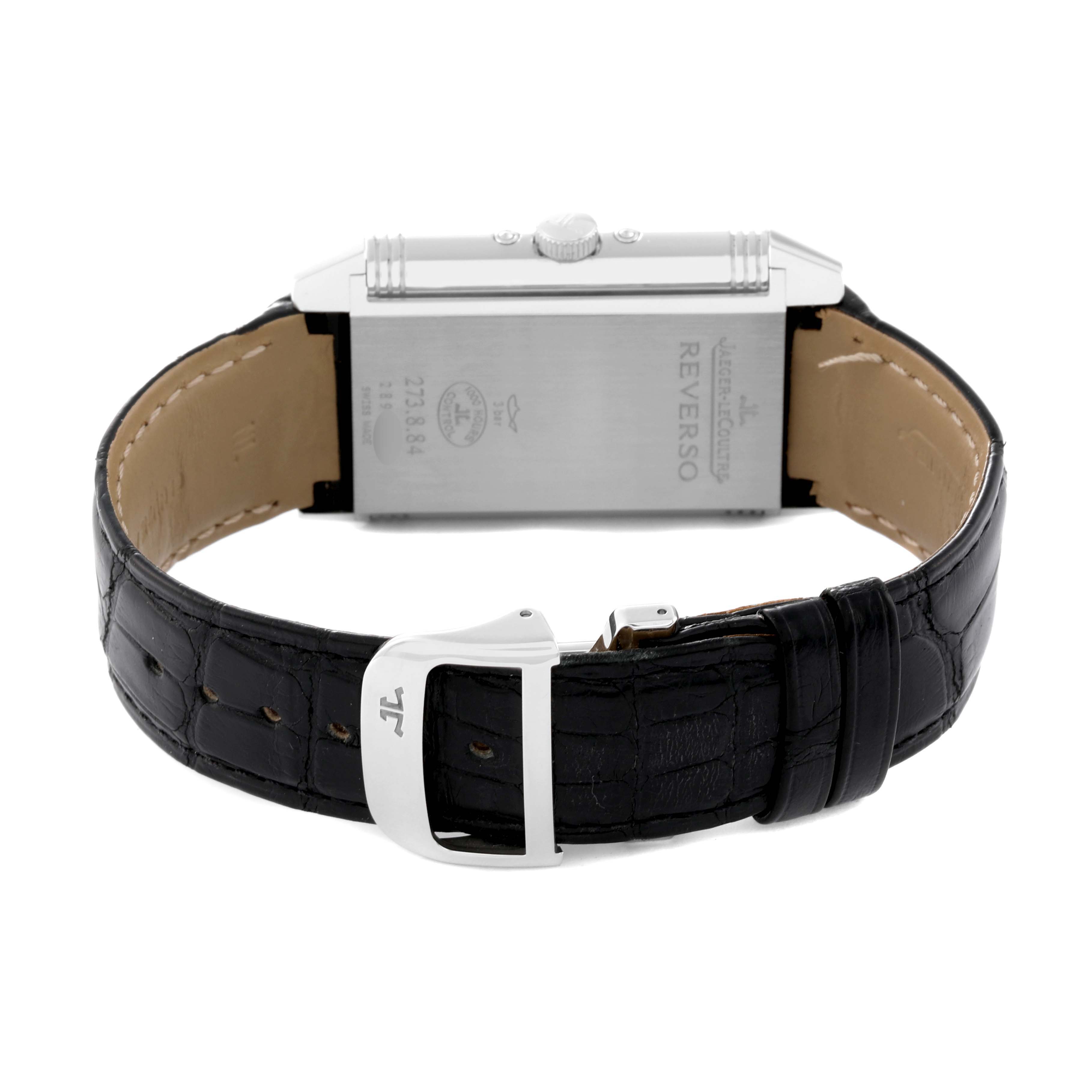 The image shows the backside of a Jaeger-LeCoultre Reverso watch, highlighting the strap, buckle, and case back details.