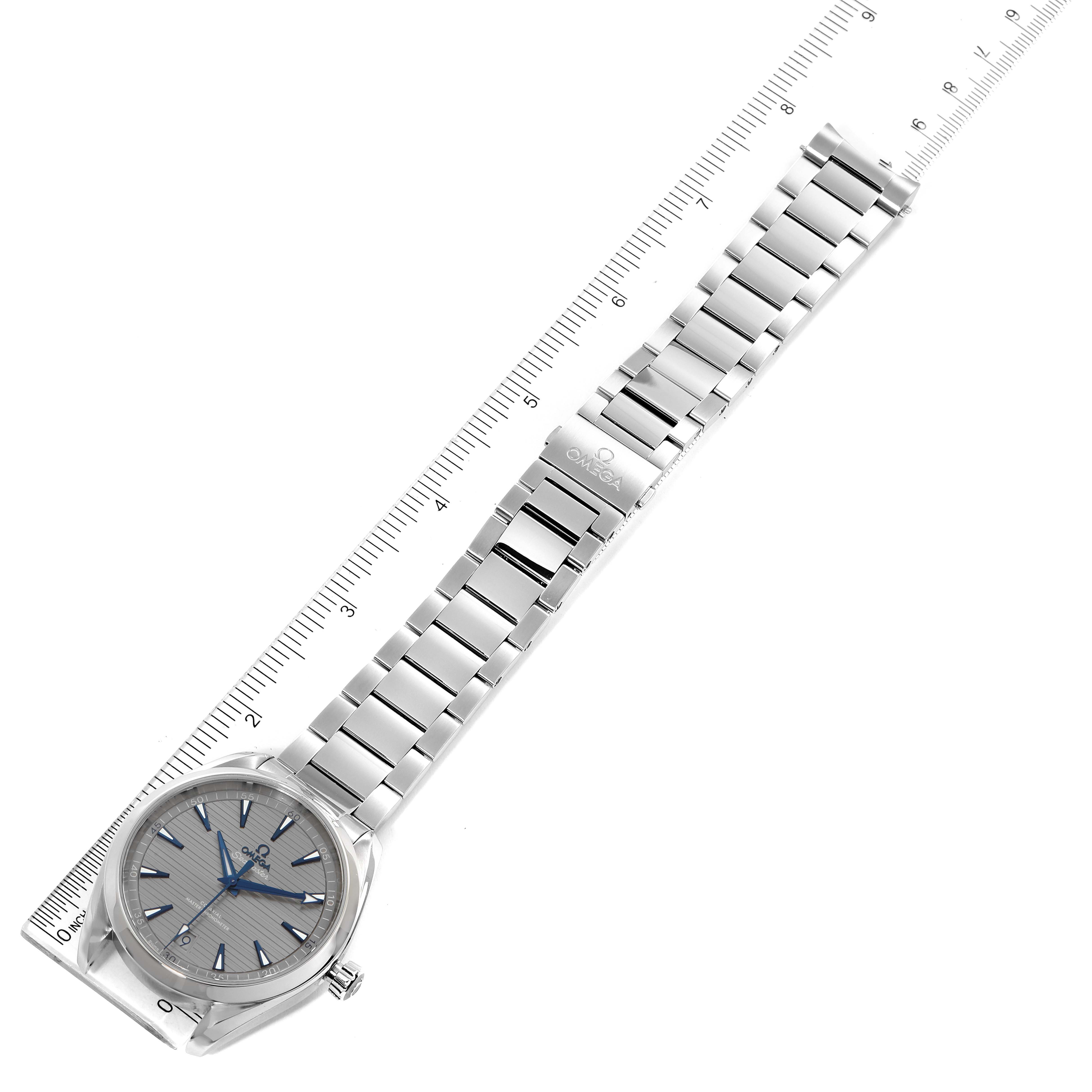 The image shows the Omega Aqua Terra 220.10.41.21.06.001 Men
s Stainless Steel Grey Dial 220.10.41.21.06.001 Men
s Stainless Steel Grey Dial watch laid flat with a ruler next to it, revealing the dial, bracelet, and clasp.