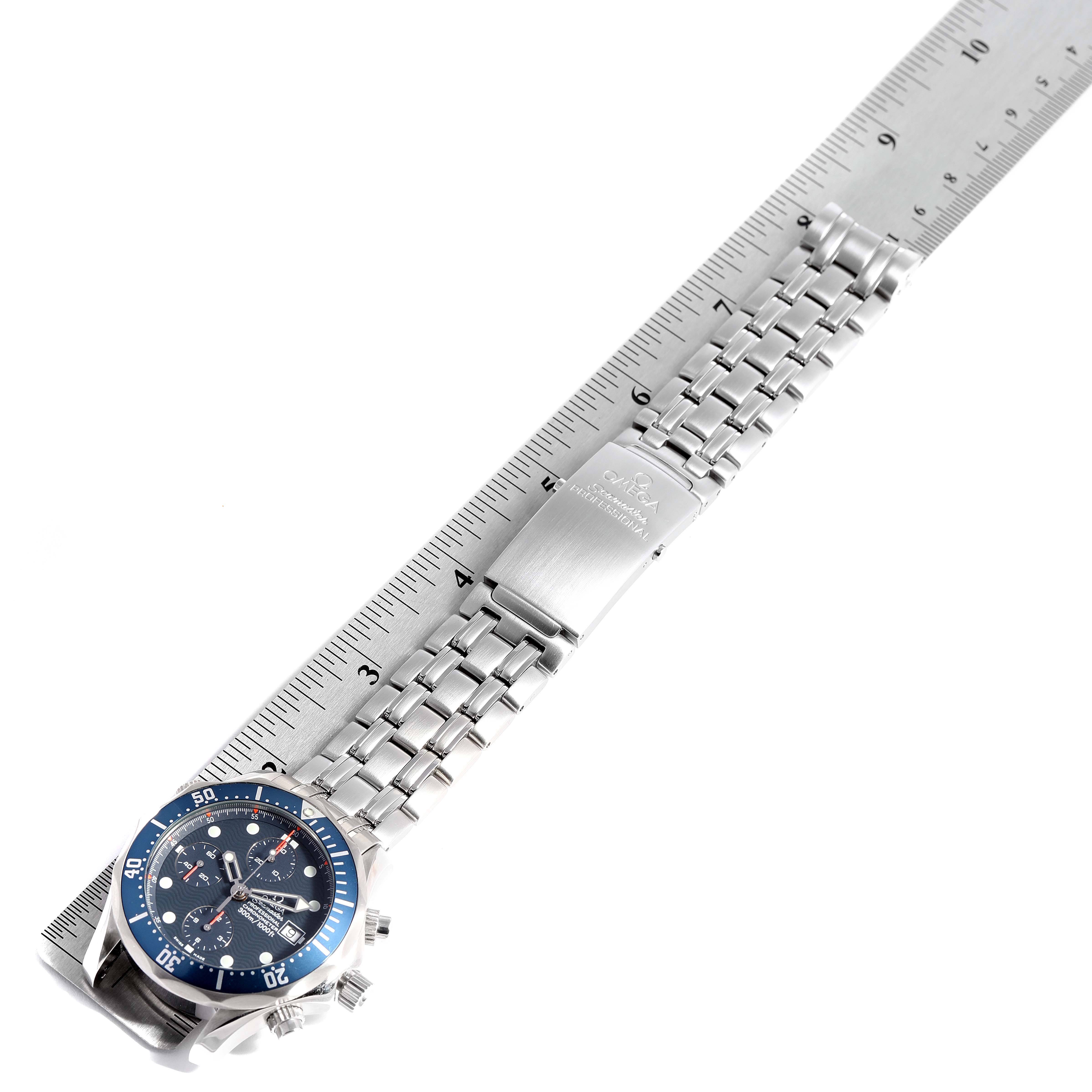 The image shows an Omega Seamaster 2599.80.00 Men
s Stainless Steel Blue Dial 2599.80.00 Men
s Stainless Steel Blue Dial watch laid flat along a ruler, highlighting the face, bezel, and bracelet.