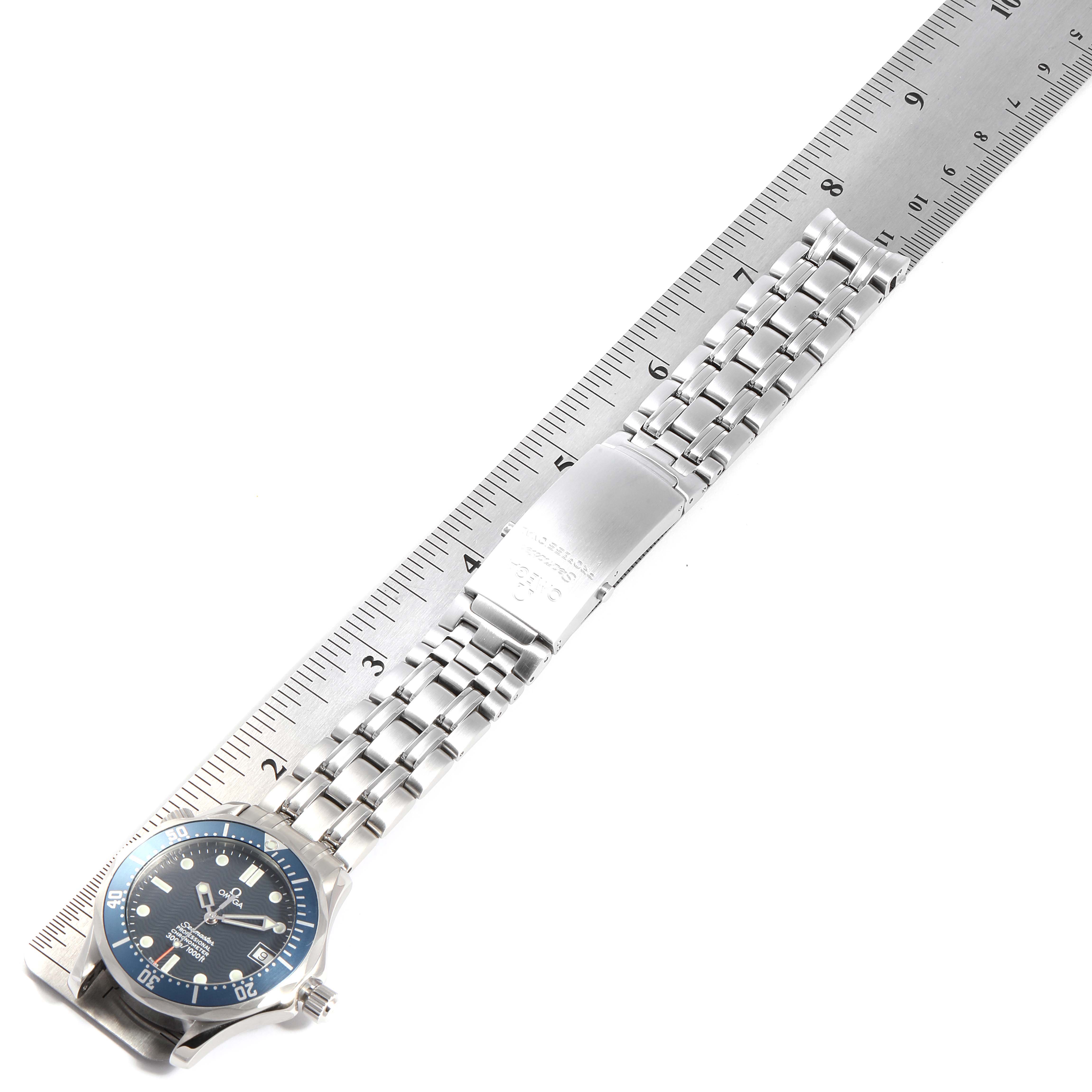 The image shows a side view of an Omega Seamaster 27803 Men
s Stainless Steel Blue Dial 27803 Men
s Stainless Steel Blue Dial watch, highlighting the watch face, bracelet, and clasp, measured against a ruler.
