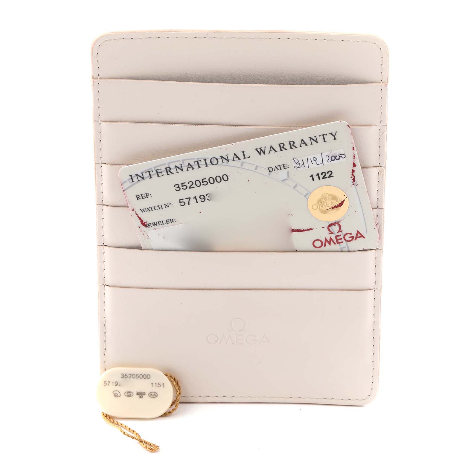 The image shows a warranty card and tag for an Omega Speedmaster 3520.50.00 Men's Stainless Steel Black Dial 3520.50.00 Men's Stainless Steel Black Dial, displayed on a cream cardholder.