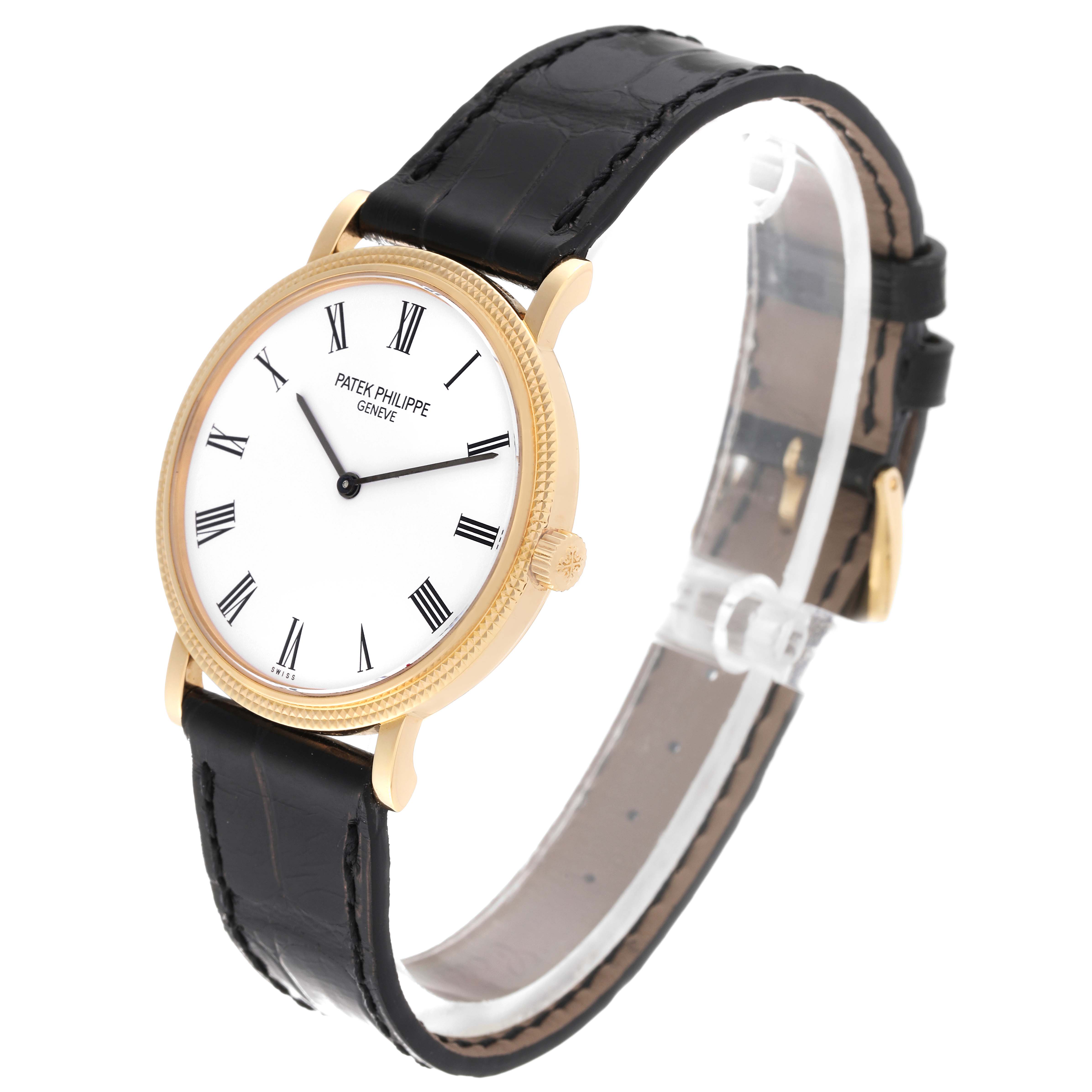 The image shows a side-angle view of a Patek Philippe Calatrava 5120J Men
s Yellow Gold White Dial 5120J Men
s Yellow Gold White Dial watch with a white dial, black leather strap, and gold casing.