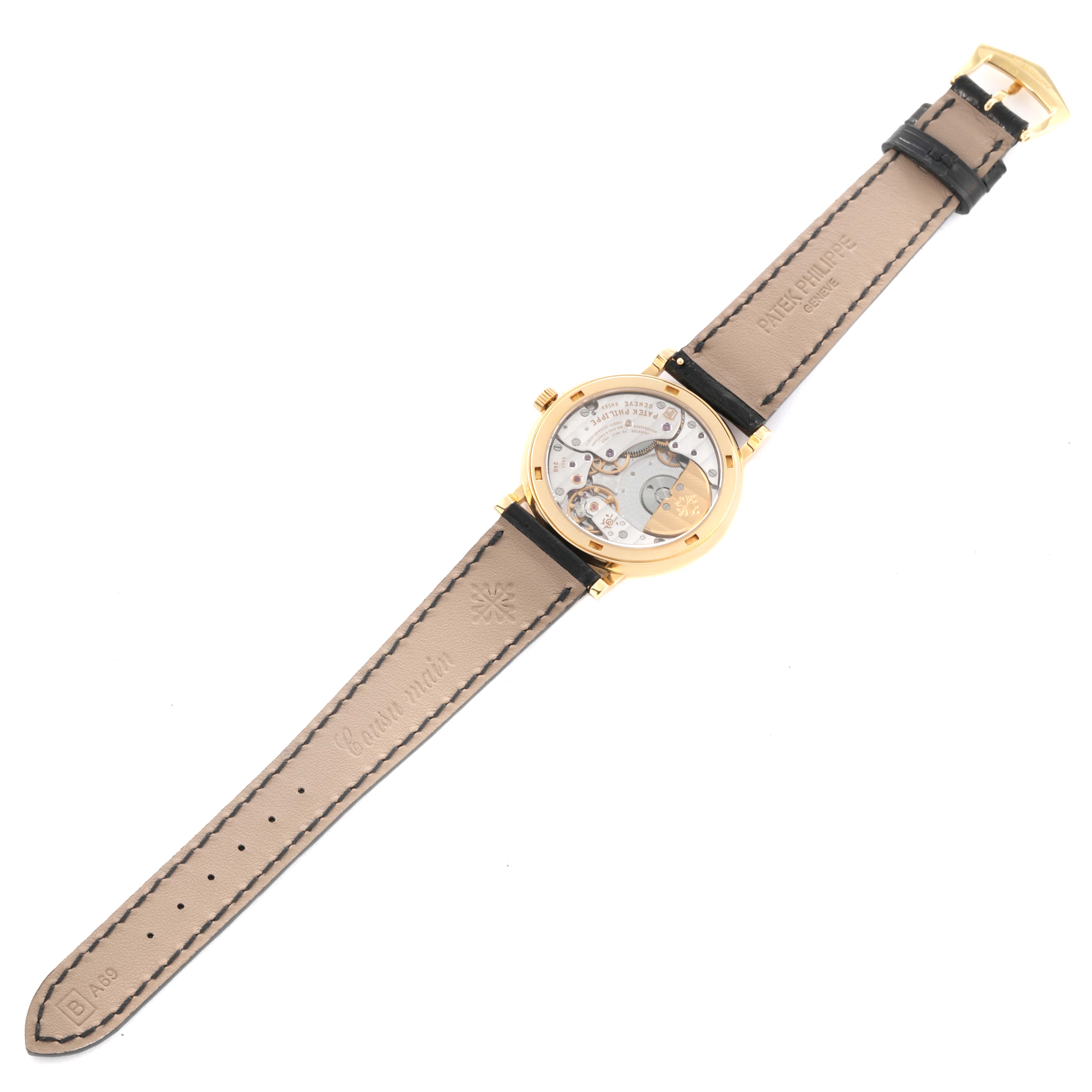 The image shows the back view of a Patek Philippe Calatrava 5120J Men
s Yellow Gold White Dial 5120J Men
s Yellow Gold White Dial watch, displaying its movement and leather strap.