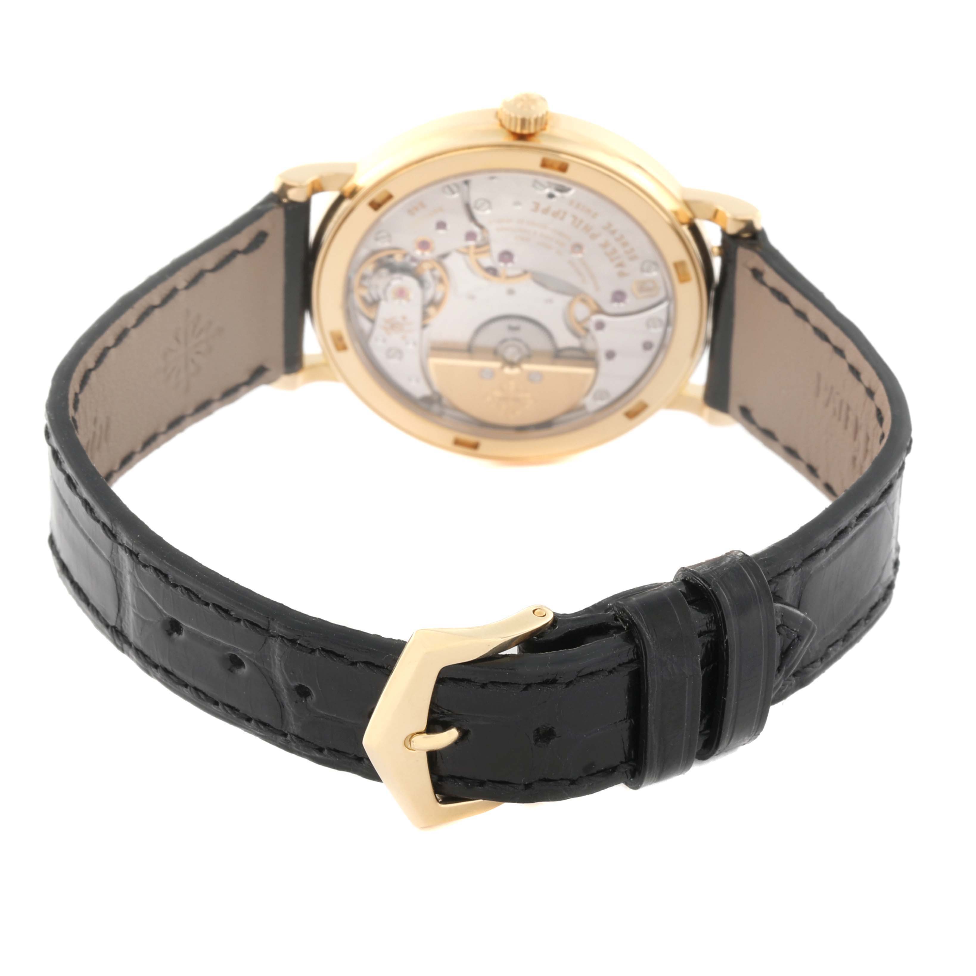 The image shows the back view of a Patek Philippe Calatrava 5120J Men
s Yellow Gold White Dial 5120J Men
s Yellow Gold White Dial watch, highlighting its movement and black leather strap.