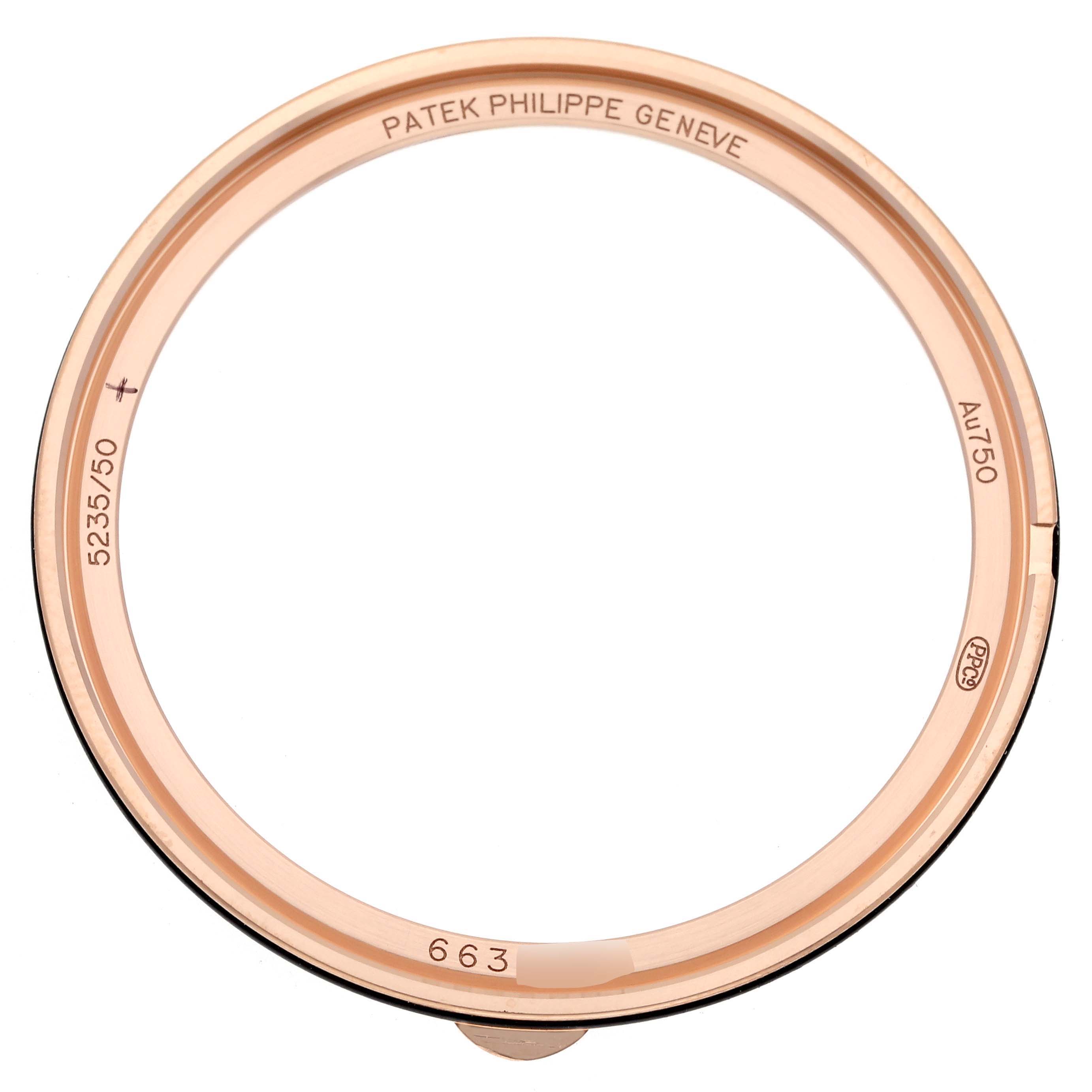 The image shows a close-up of the bezel frame from a Patek Philippe Complications 5235/50R-001 Men's Rose Gold Black Dial 5235/50R-001 Men's Rose Gold Black Dial watch, displaying internal engravings.