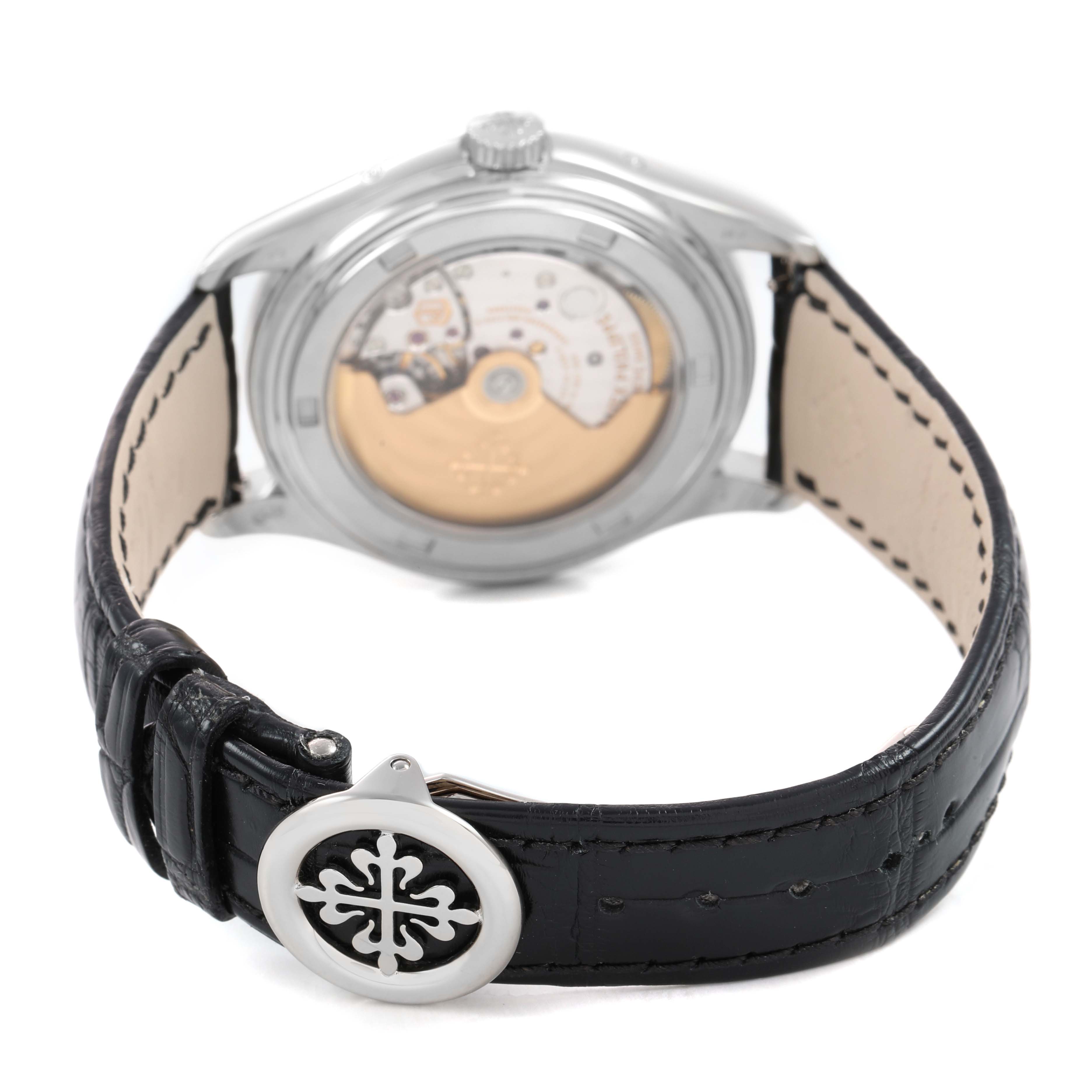 The Patek Philippe Complications 5146G Men's White Gold White Dial watch is shown from a rear angle, highlighting the movement and the leather strap with logo clasp.