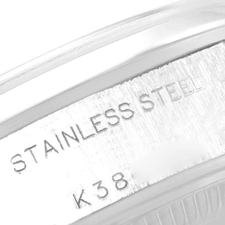 The image shows a close-up angle of the casing edge of a Rolex Date 79160 Women
s Stainless Steel Silver Dial 79160 Women
s Stainless Steel Silver Dial model watch, highlighting the "Stainless Steel" engraving.