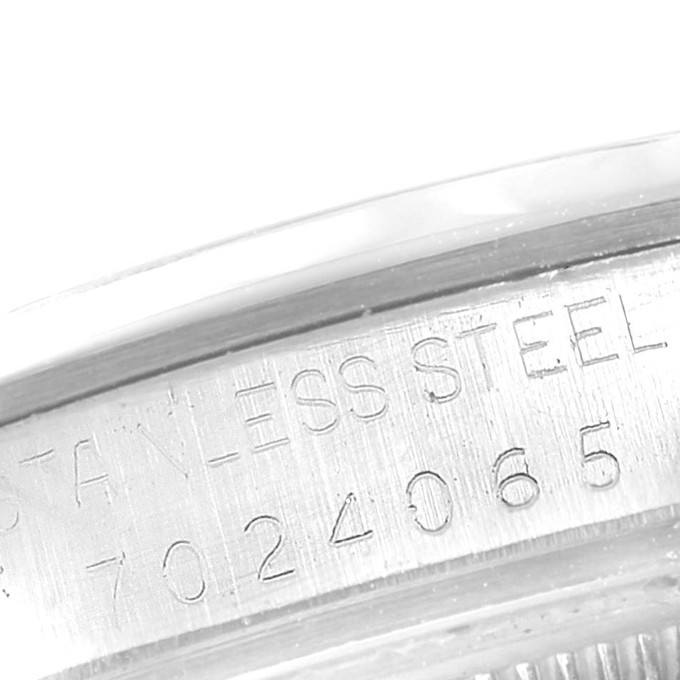 This close-up image of a Rolex Vintage Collection 15000 Men's Stainless Steel Silver Dial 15000 Men's Stainless Steel Silver Dial model shows the engraved serial number and "STAINLESS STEEL" text on its case.