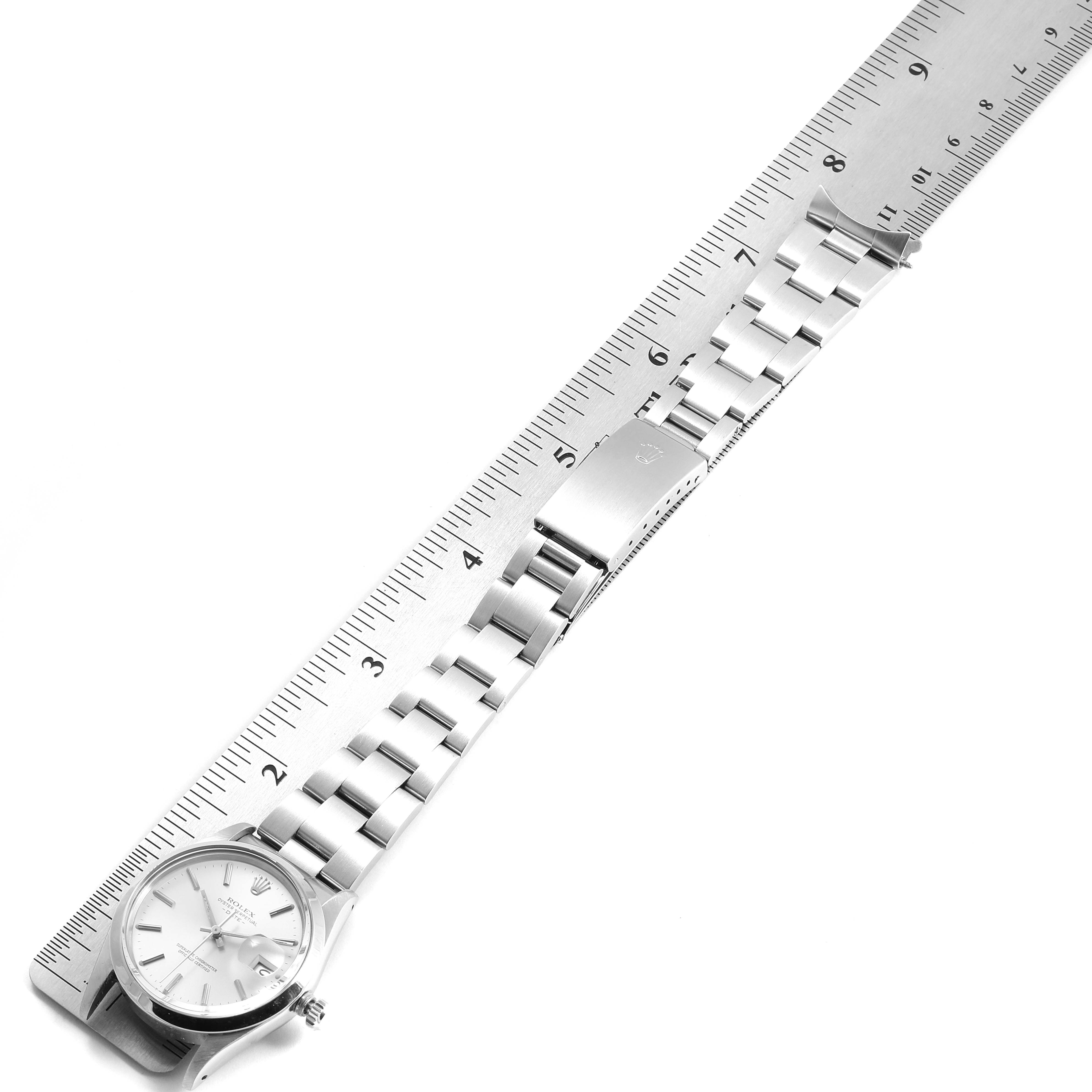 The image shows a flat lay view of the Rolex Vintage Collection 15000 Men's Stainless Steel Silver Dial 15000 Men's Stainless Steel Silver Dial watch, highlighting its face, bracelet, and clasp alongside a ruler for scale.