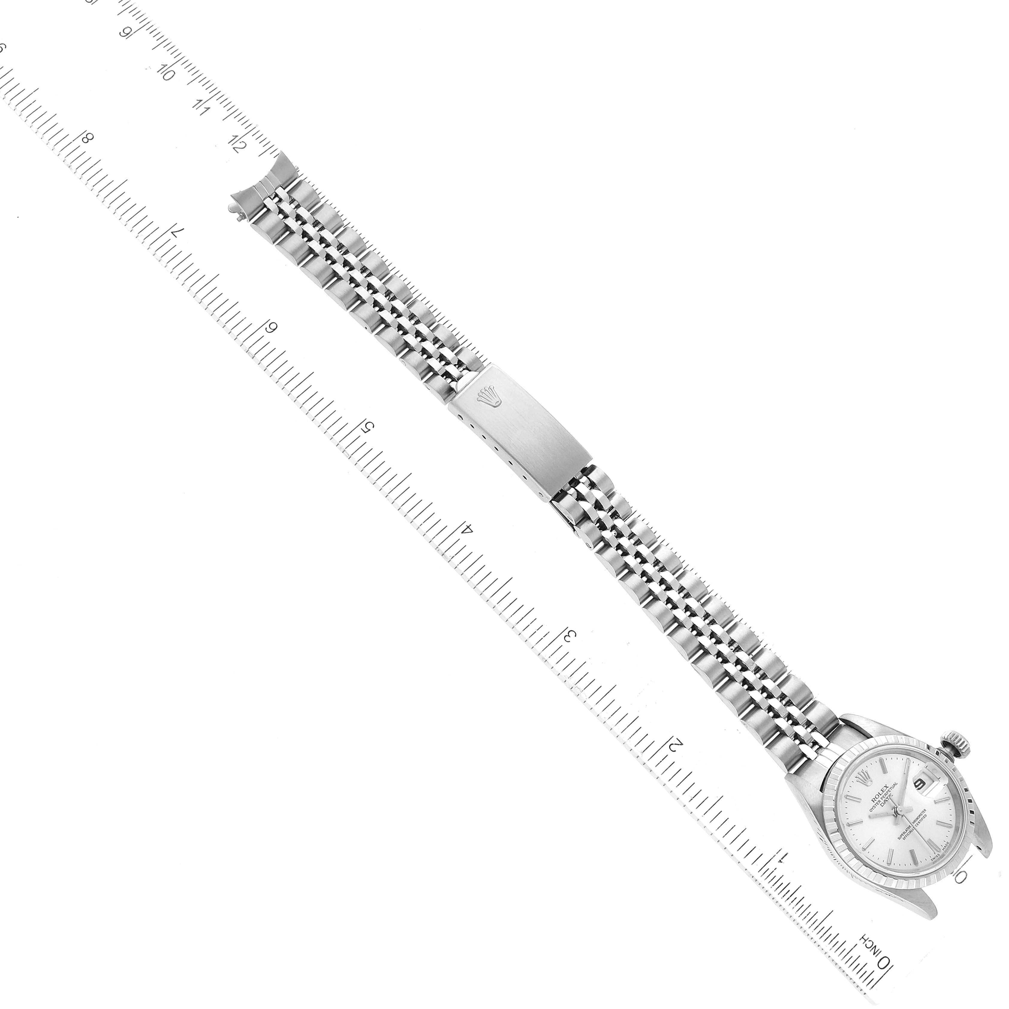 This image shows a Rolex Date 69240 Women's Stainless Steel Silver Dial 69240 Women's Stainless Steel Silver Dial model watch placed next to a ruler, displaying its full length and metal bracelet.