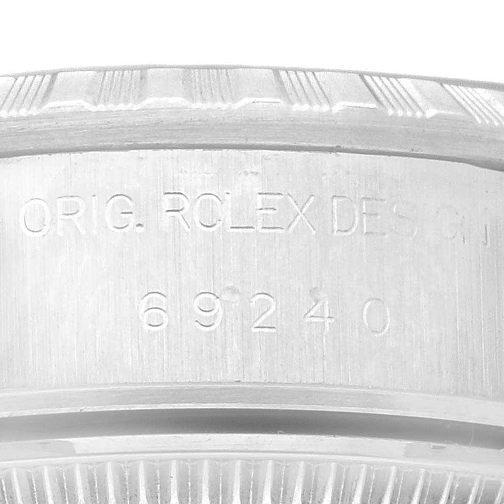 The image shows a close-up of the serial number and part of the bezel of a Rolex Date 69240 Women's Stainless Steel Silver Dial 69240 Women's Stainless Steel Silver Dial model watch.