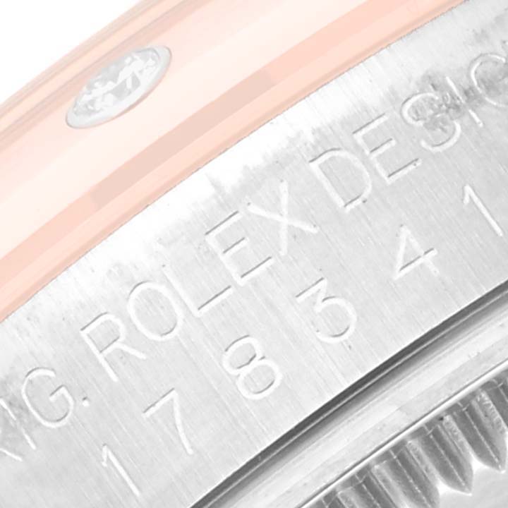 The image shows a close-up of the case and bezel side of a Mid-Size Rolex watch, highlighting the engraving on the metal.