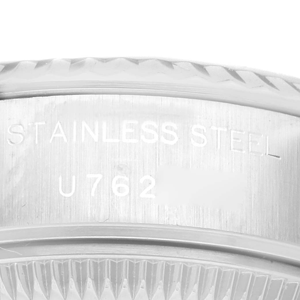 The image shows the side view of a Rolex Datejust 79174 Women's Stainless Steel Black Dial 79174 Women's Stainless Steel Black Dial watch case, highlighting the "STAINLESS STEEL" engraving and part of the serial number.