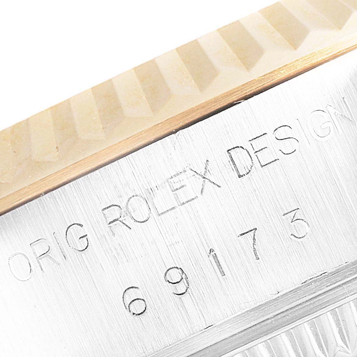 This image shows a close-up angle of the engraved model number and fluted bezel on the Rolex Datejust 69173 Women's Steel and Gold (two tone) Blue Dial 69173 Women's Steel and Gold (two tone) Blue Dial watch.