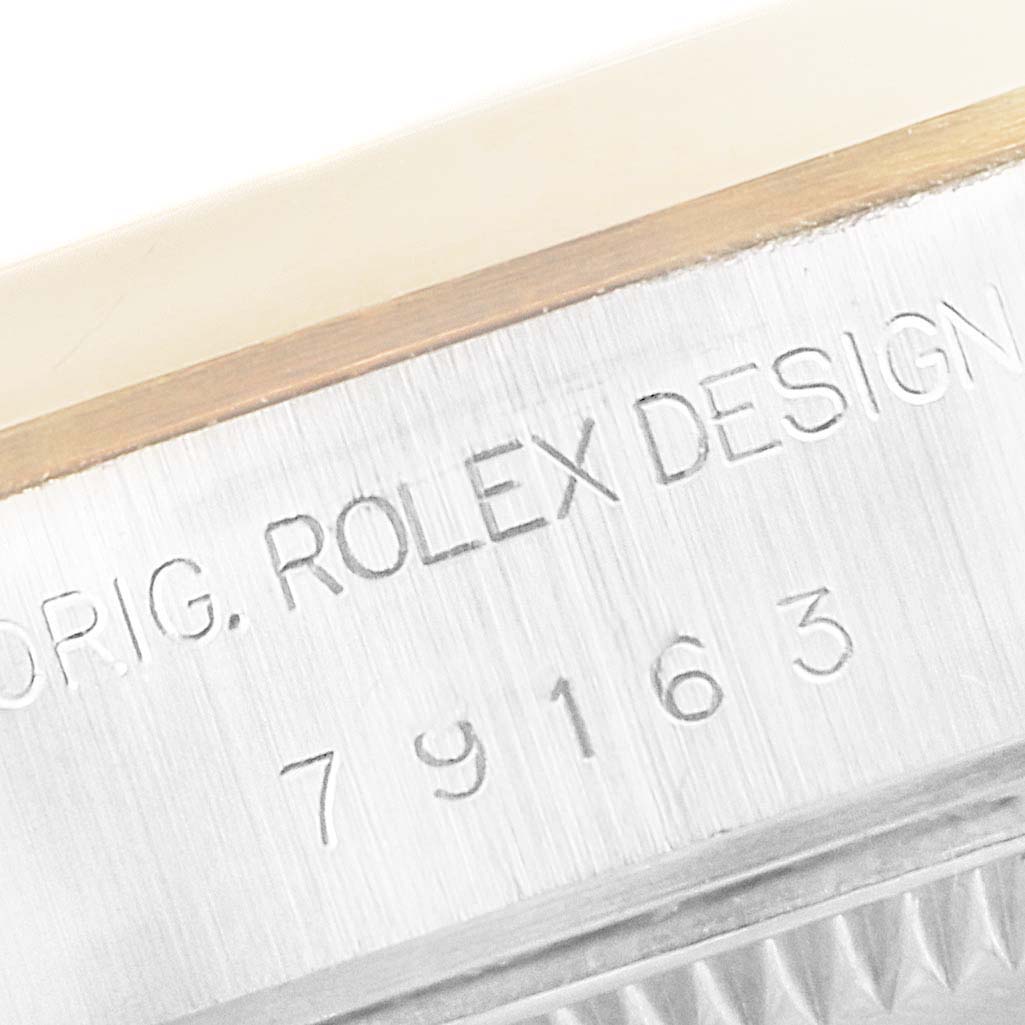 This image shows a close-up of the side of a Rolex Datejust 79163 Women's Steel and Gold (two tone) Mother of Pearl Dial 79163 Women's Steel and Gold (two tone) Mother of Pearl Dial watch, displaying the engraved model number and "ROLEX DESIGN."