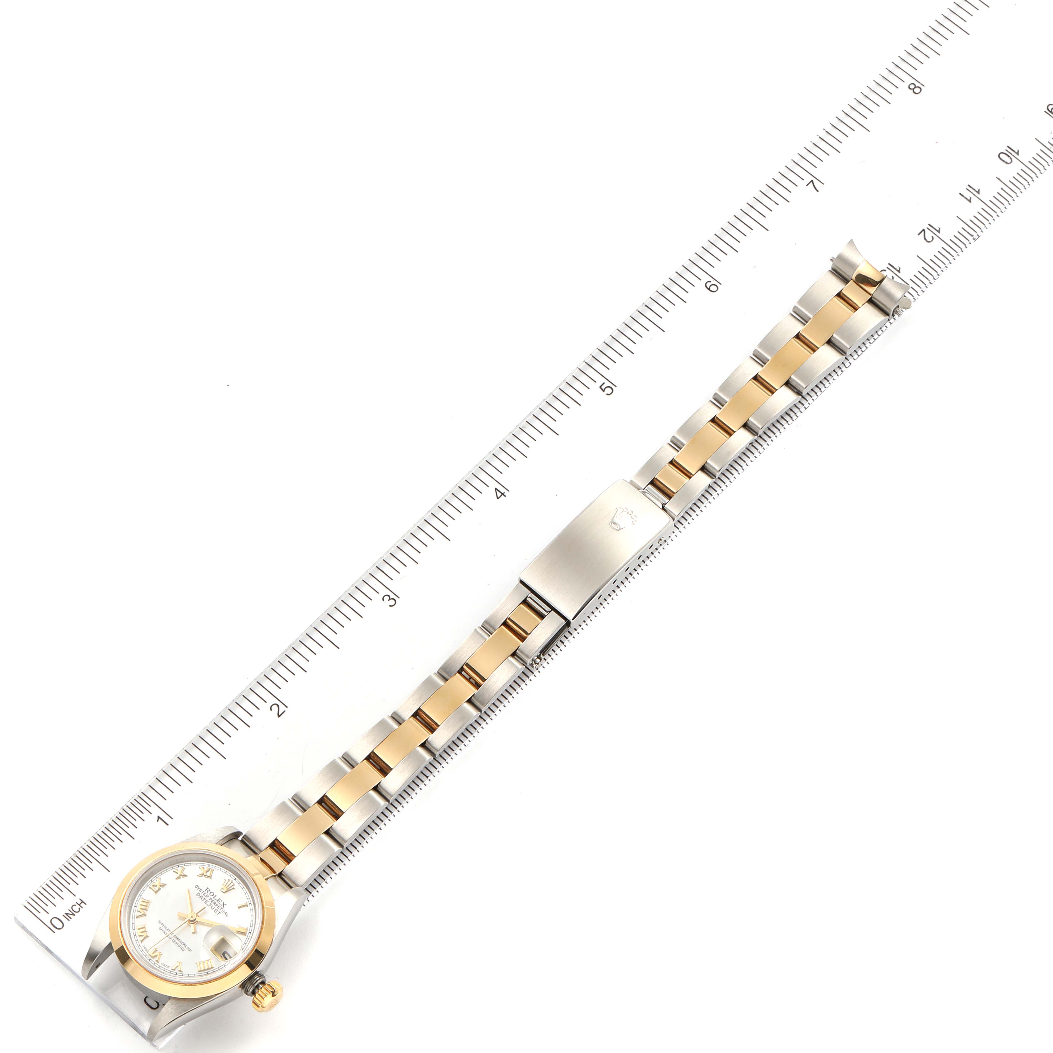 The image shows a Rolex Datejust 79163 Women's Steel and Gold (two tone) Mother of Pearl Dial 79163 Women's Steel and Gold (two tone) Mother of Pearl Dial watch from an overhead angle alongside a ruler, highlighting its bracelet and face.
