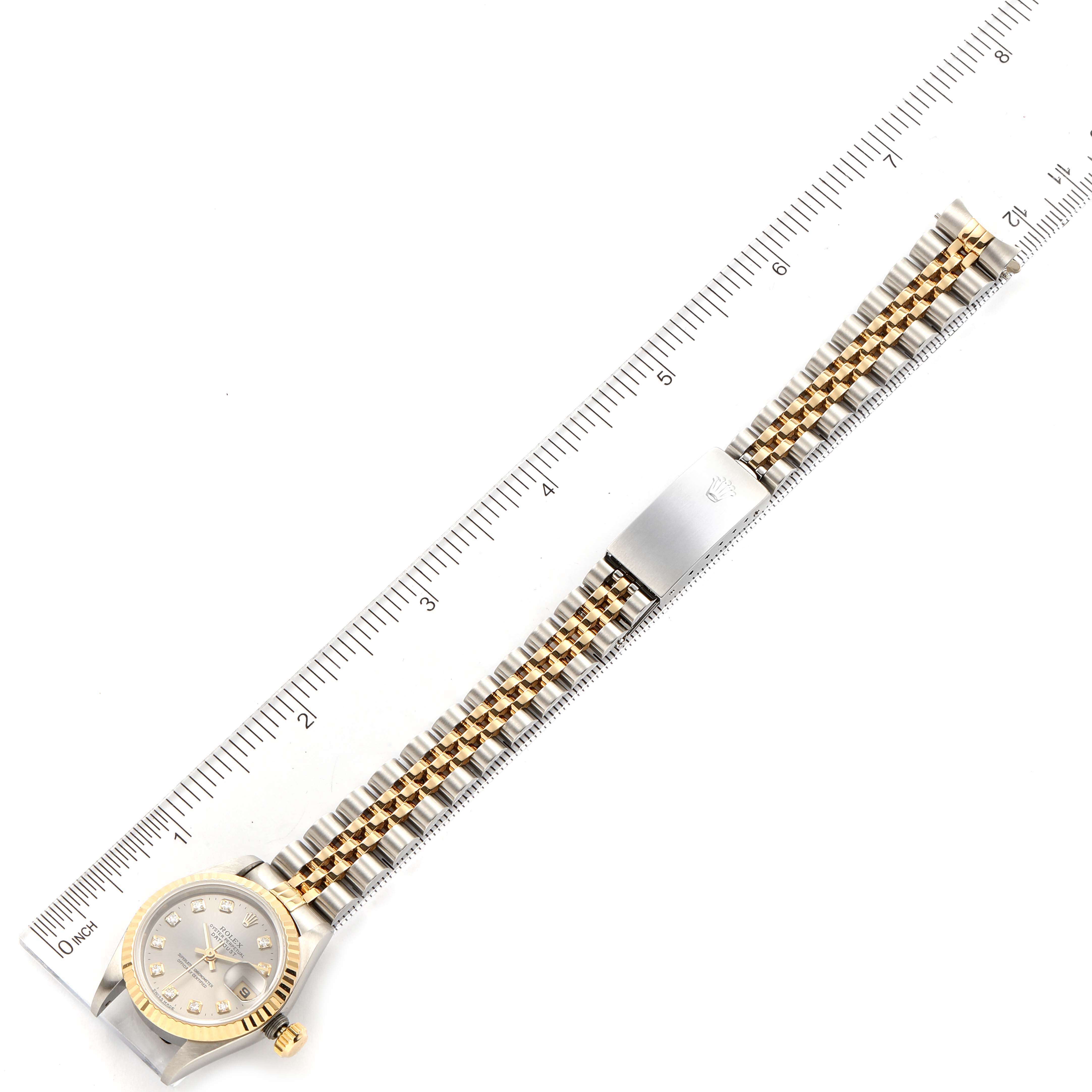 The image shows a top-down view of a Rolex Datejust 69173 Women's Steel and Gold (two tone) Silver Dial 69173 Women's Steel and Gold (two tone) Silver Dial watch with a ruler alongside, highlighting the watch face and bracelet.