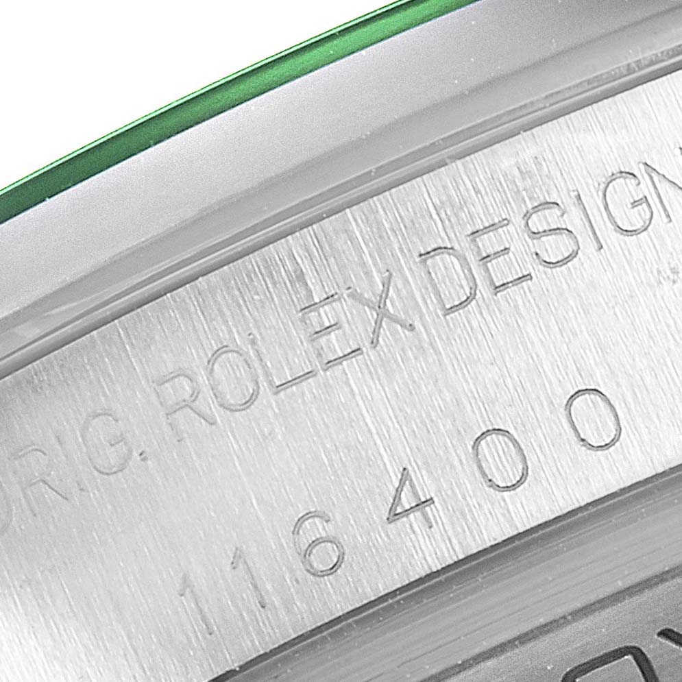 This close-up image shows the engraved serial/model number and part of the green bezel of a Rolex Milgauss 116400V Men
s Stainless Steel Black Dial 116400V Men
s Stainless Steel Black Dial watch.