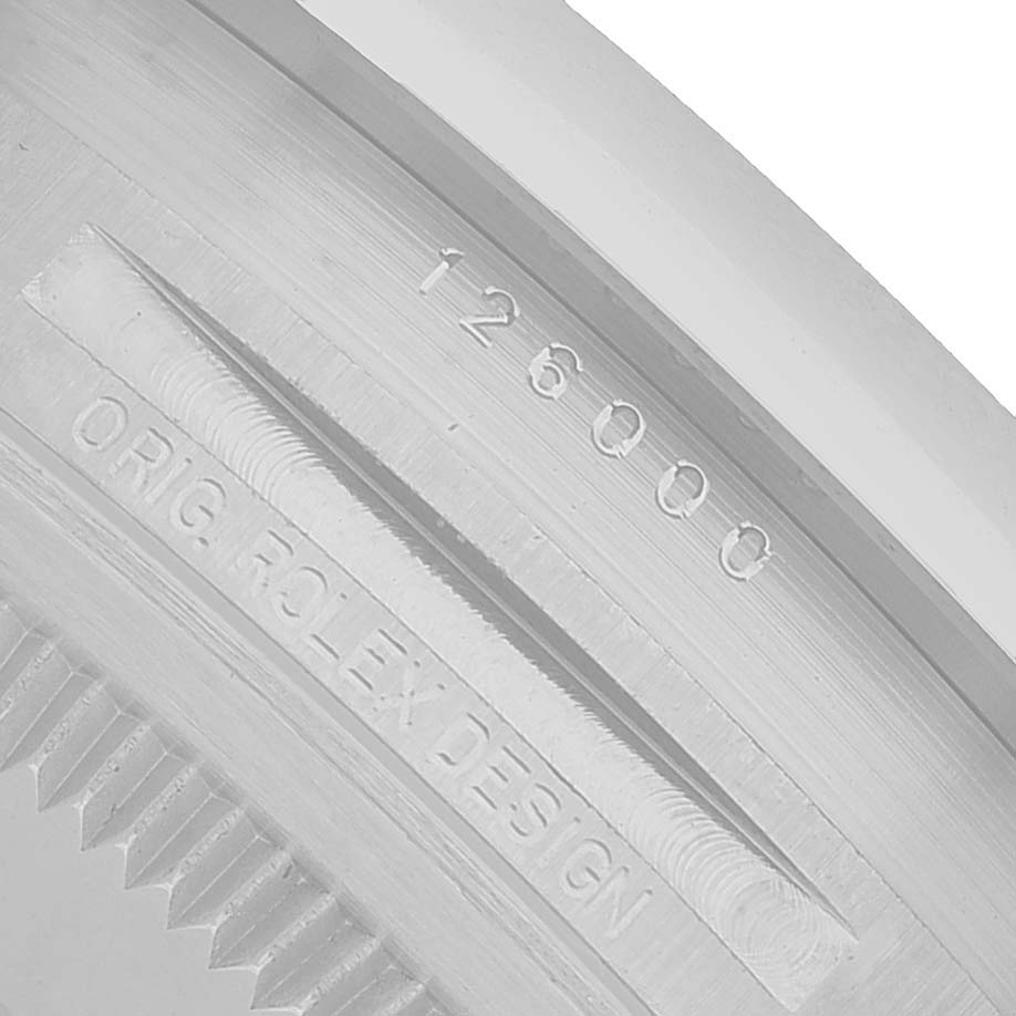 This image shows a close-up of the engraving on the case side of a Rolex Oyster Perpetual 126000 Men's Stainless Steel Pink Dial, featuring the serial number and design markings.